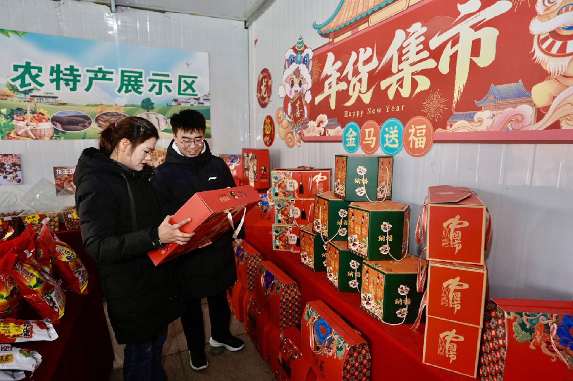 游客3日在宁夏固原市西吉县年货大集上选购年货产品。（图：新华社）