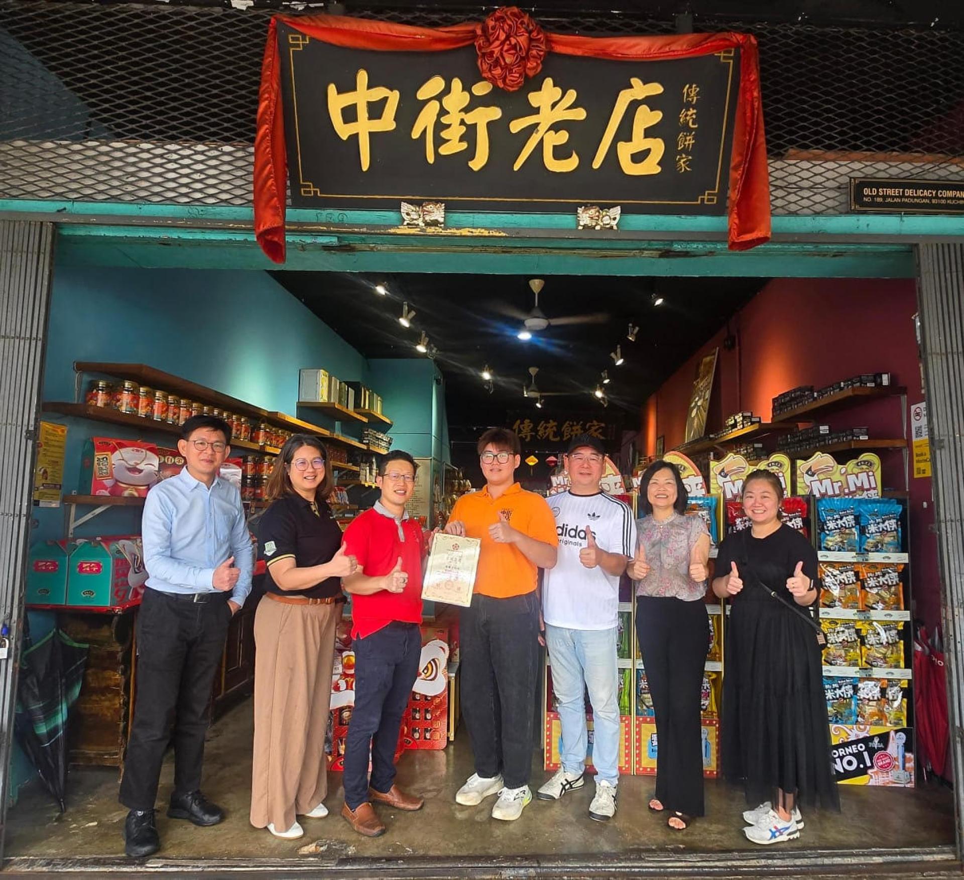 一中校友会会长李嘉浩（左3）颁发感谢证书给中街老店代表，感谢该店慷慨赞助新春礼品予退休老师。右3为号东黄冀义校友。