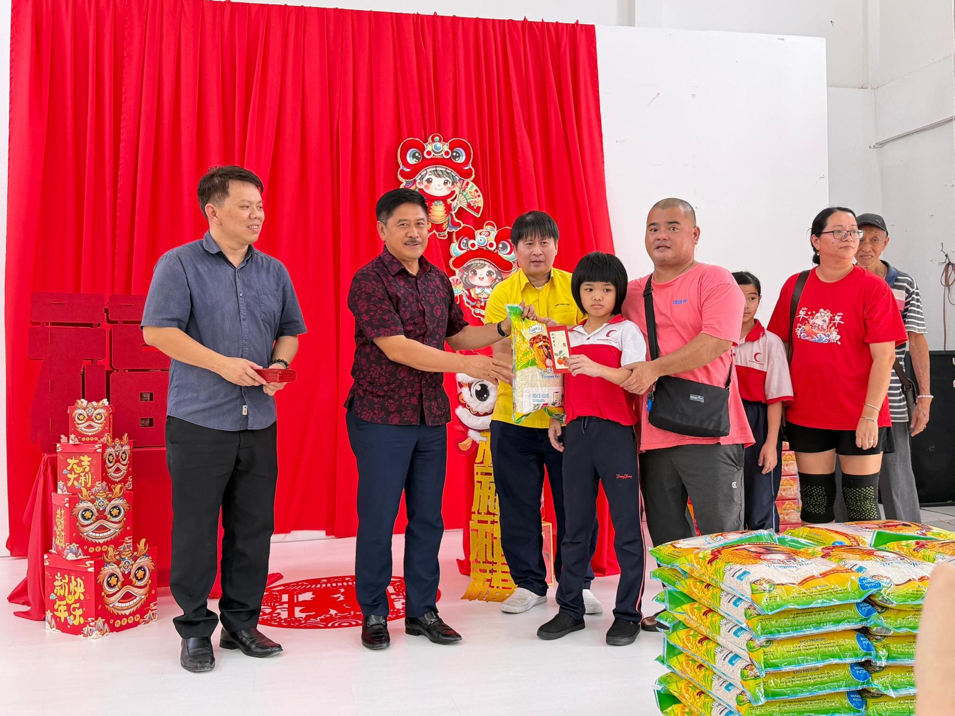 砂拉越青年、体育与企业发展副部长兼兰卑尔区州议员拿督立宾拉曼（左2）移交新春捐助品给受惠者。左1为甲必丹杨伟明，左3为砂人联党兰卑尔支部主席王智义。