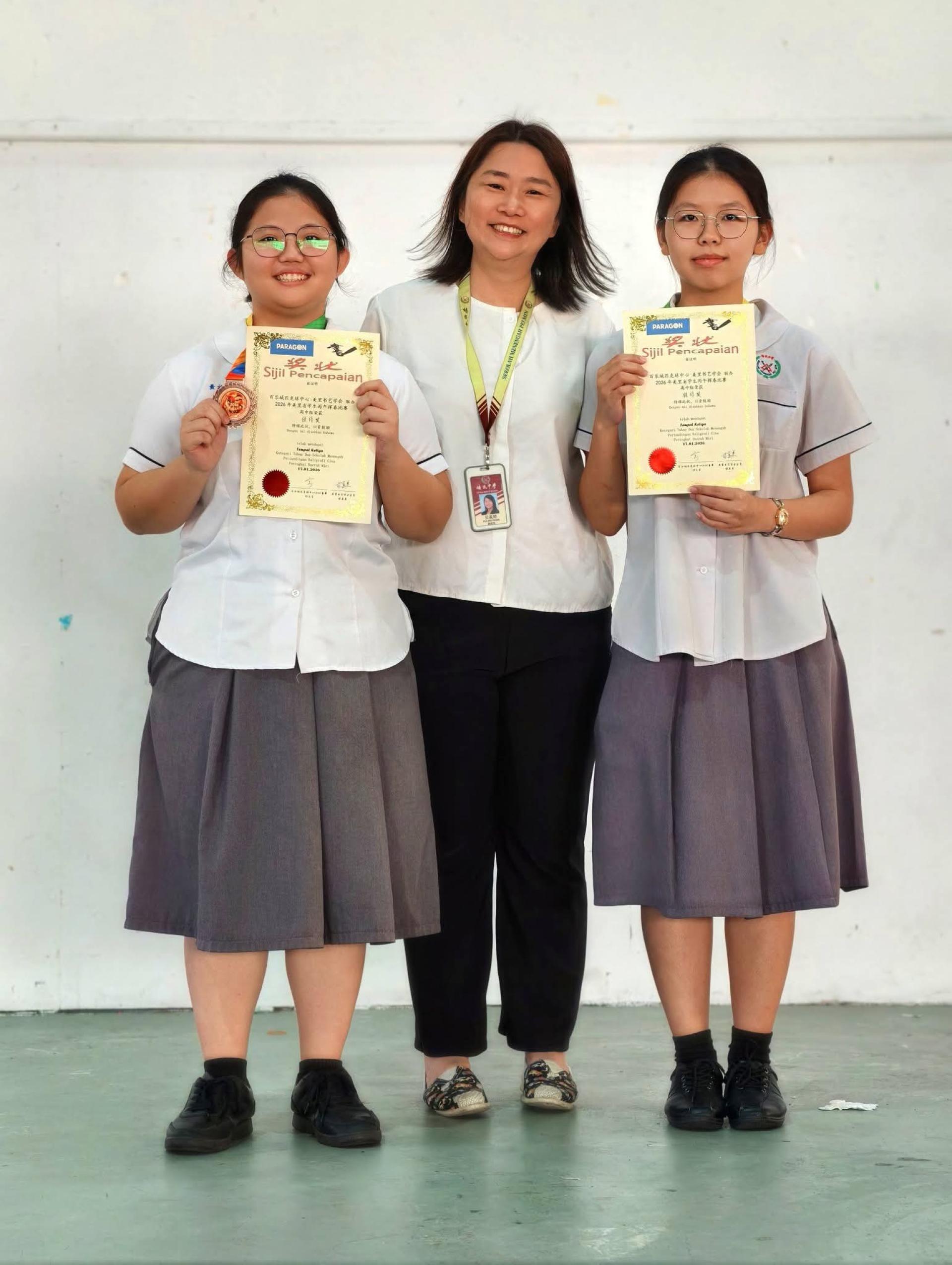 左起为培中小书法家黄祈慧、校长贝美娇、锺恩琪。