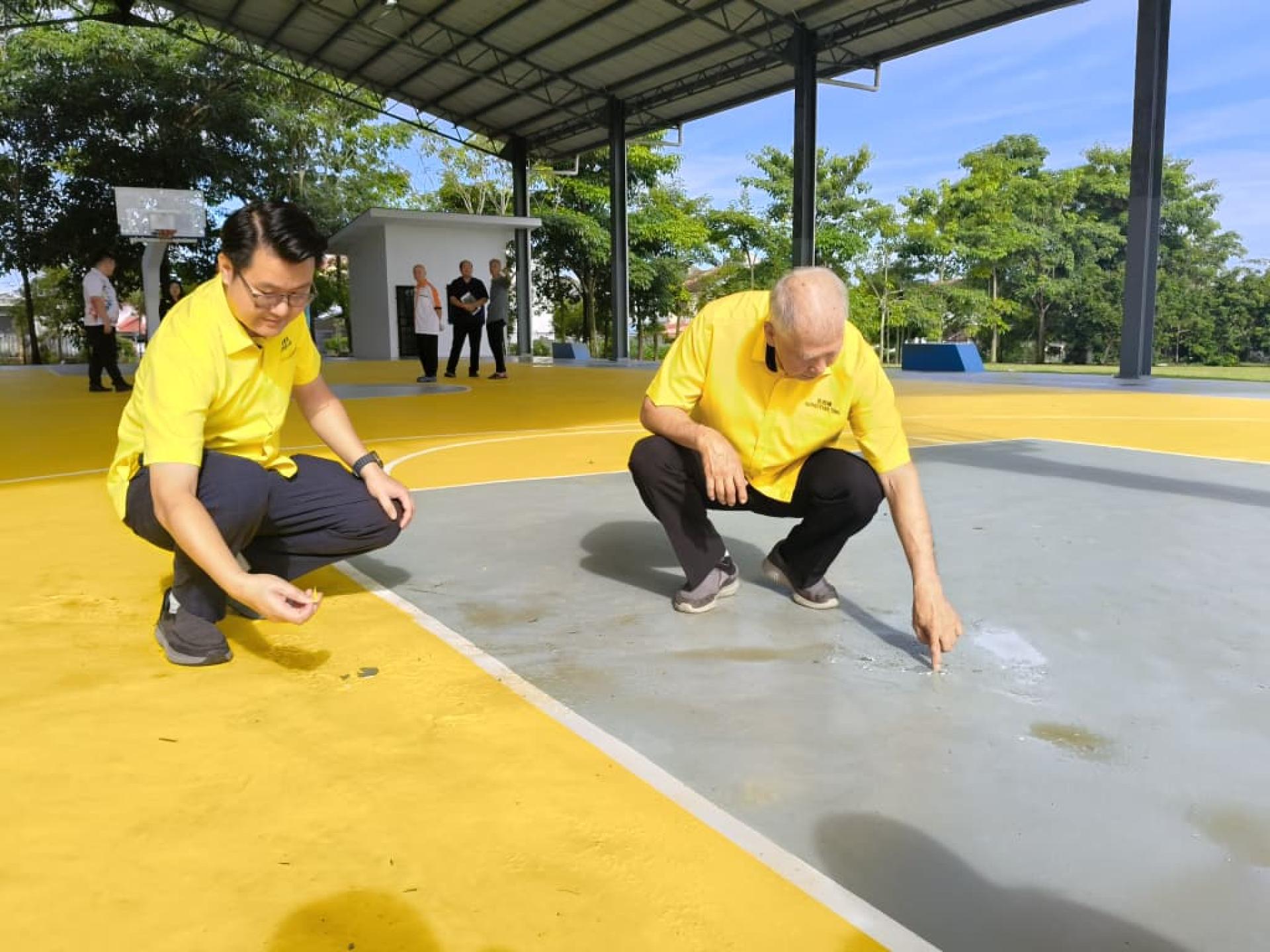 砂旅游副部长拿督陈超耀（右）检查篮球场地面出现脱漆问题。