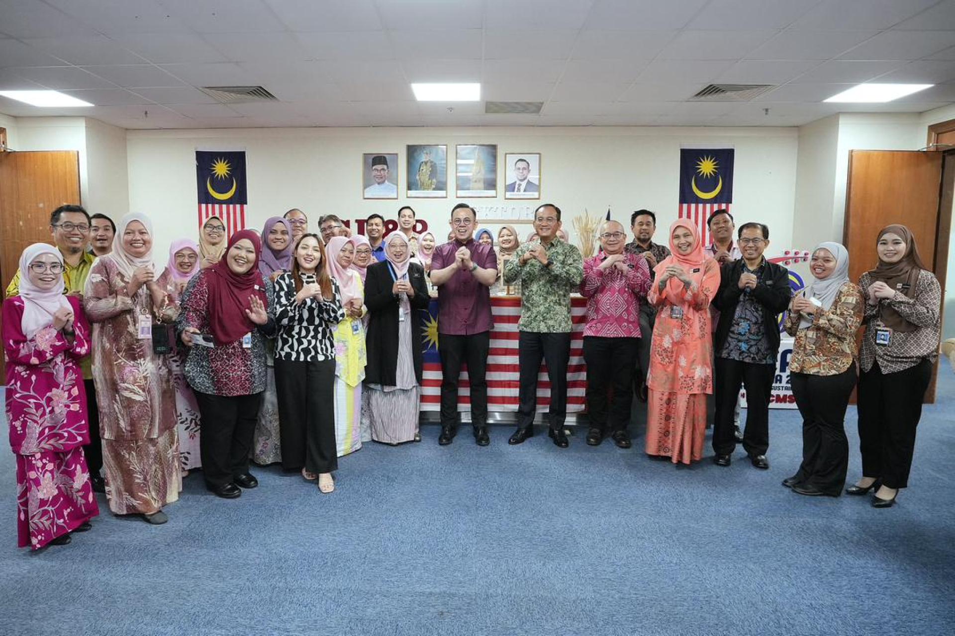 沈志强（前左7）亲自走访企业发展与合作社部旗下各局与单位，分发年柑给官员，并解释农历新年送柑的典故并合影。