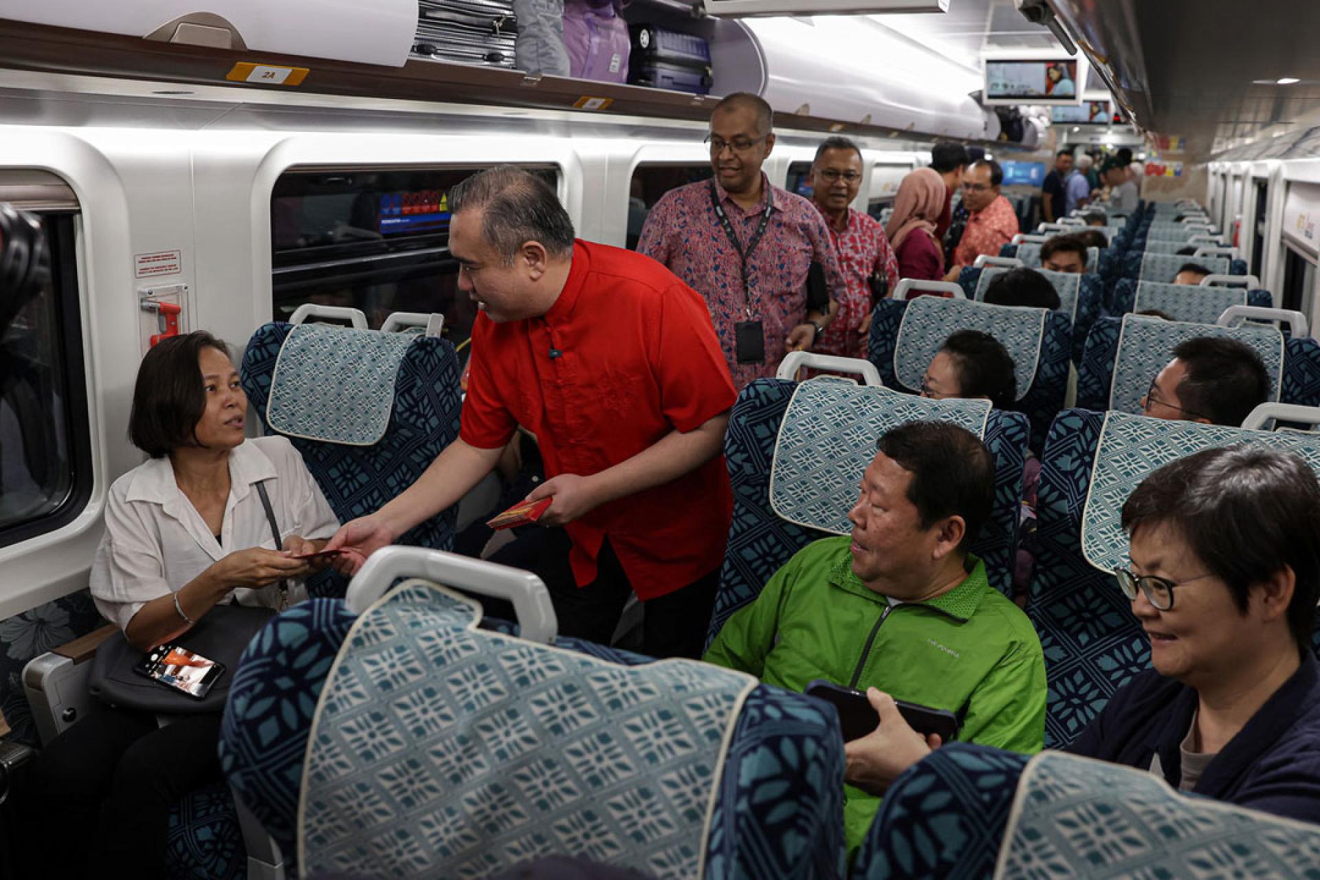 陆兆福（右2）派发红包及新年礼品给搭客。