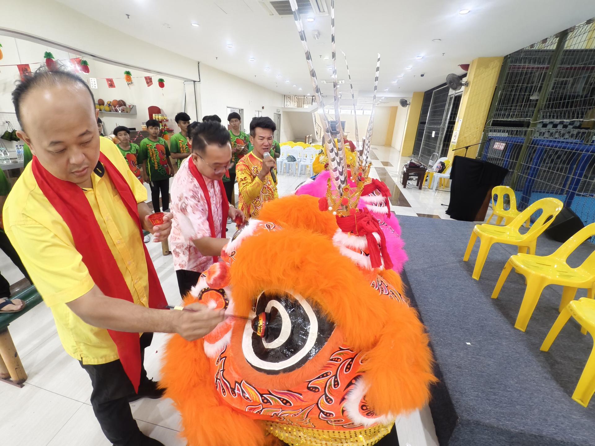 砂拉越交通部长拿督斯里李景胜的代表美里市议员熊千雨（左2）及砂旅游副部长拿督陈超耀的代表美里市议员陈立仁（左1）为金冠狮进行点睛开光仪式 。右为美里省武术协会龙狮团总教练张振昌。