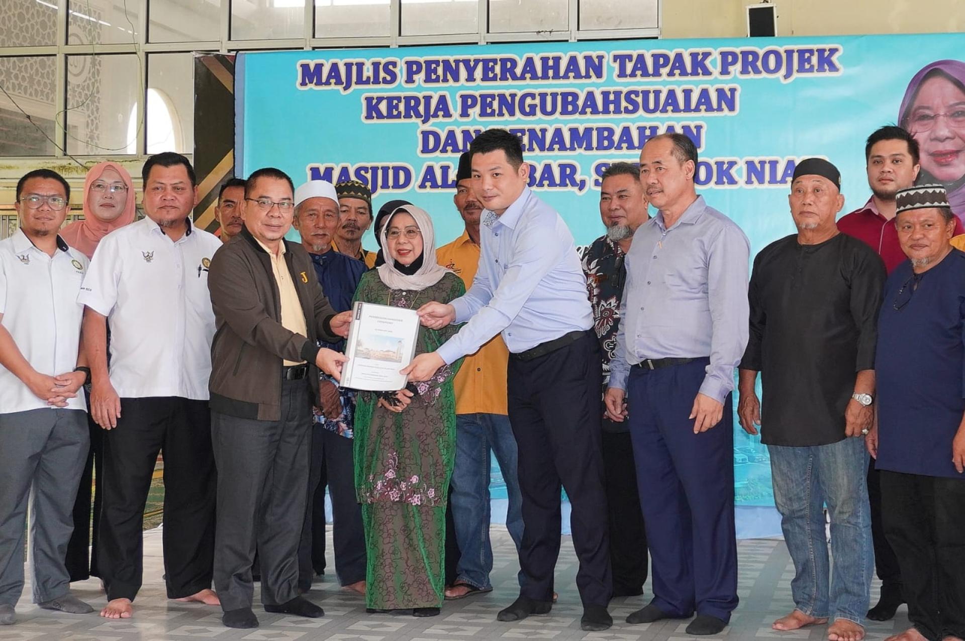 砂拉越妇女、儿童及社区和谐部副部长拿督罗茜（前排右5）见证工程和场地移交给JK99 GROUP 有限公司承包商总经理邱光杰（前排右4），前排右3为经理陈嘉兴。