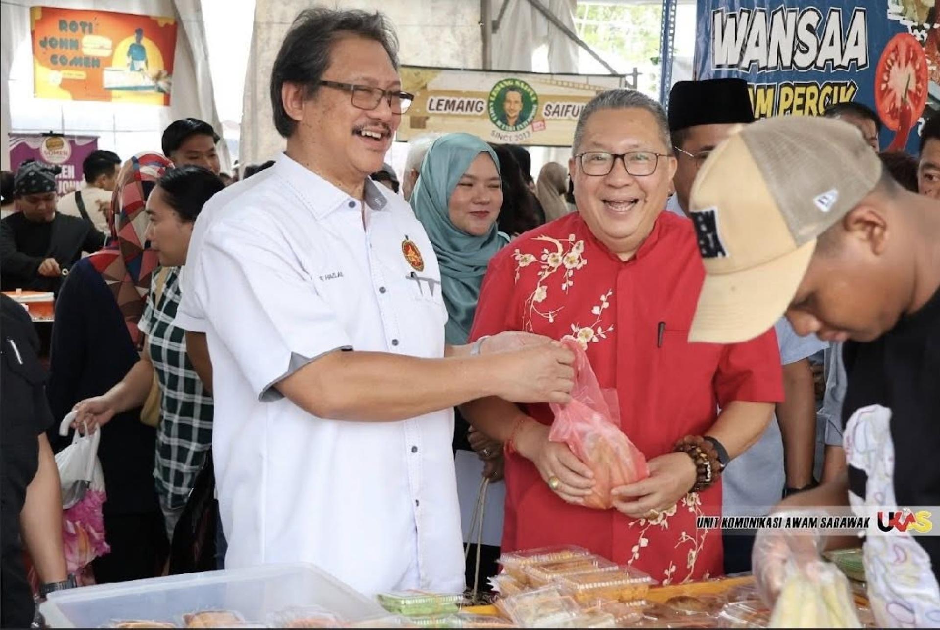 拿督哈兹兰（左）和南市市长拿督黄鸿圣（右）开心的向其中一名小贩购买食品。