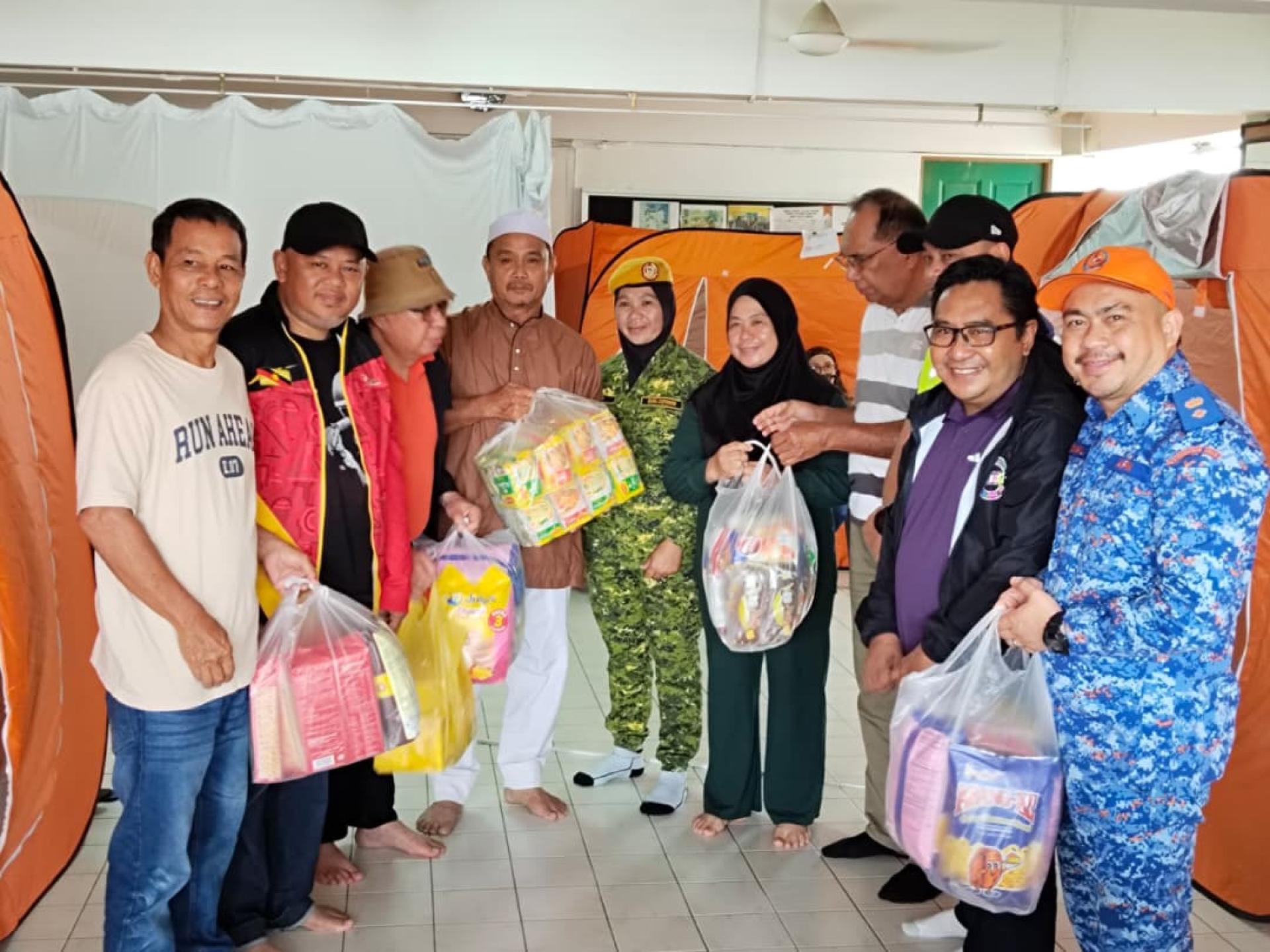 受水灾影响的灾民被妥善安排在临时疏散中心，并获得分配食品。