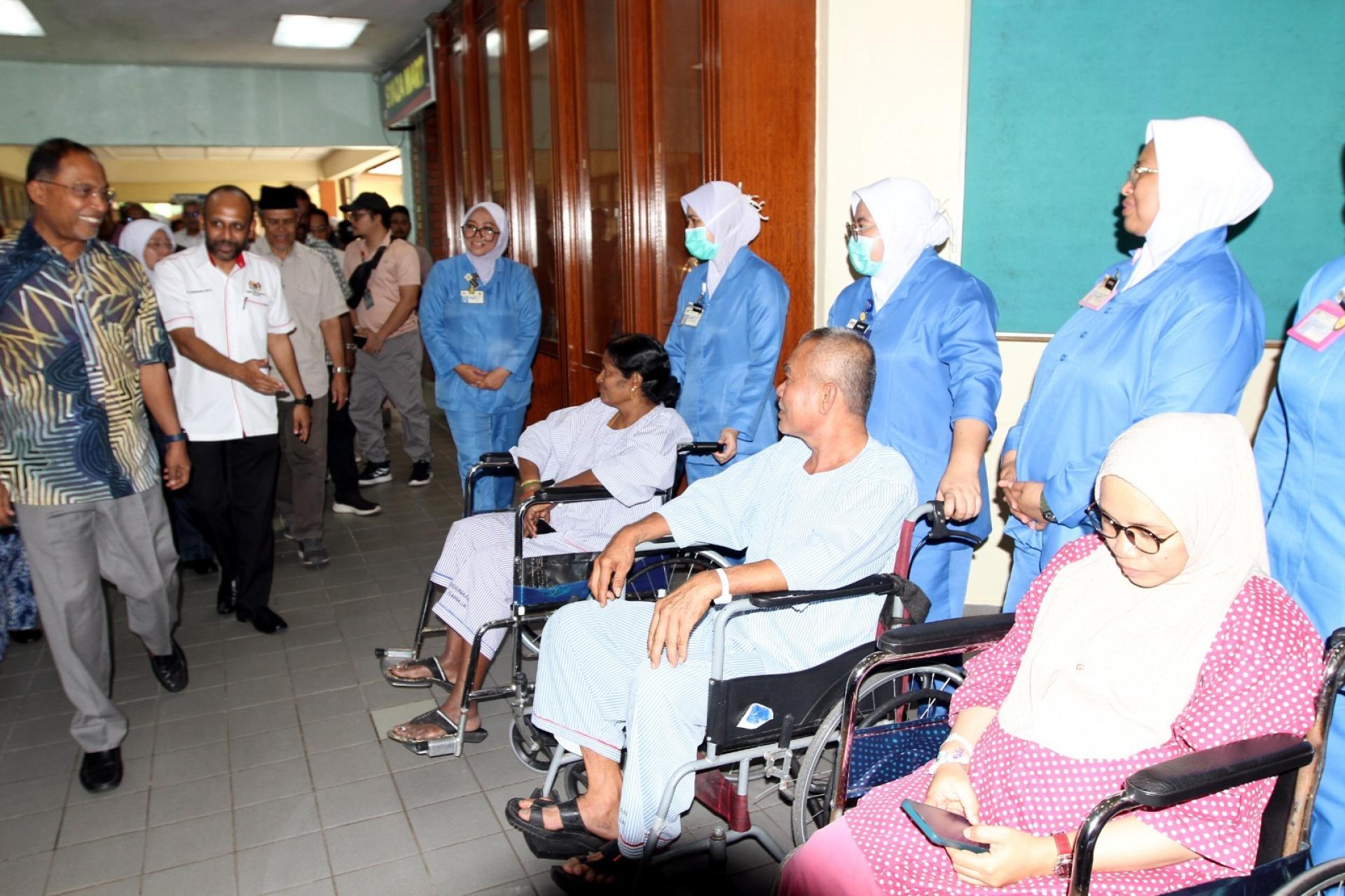 赞比里（左）前往斯里曼绒医院探访病患。