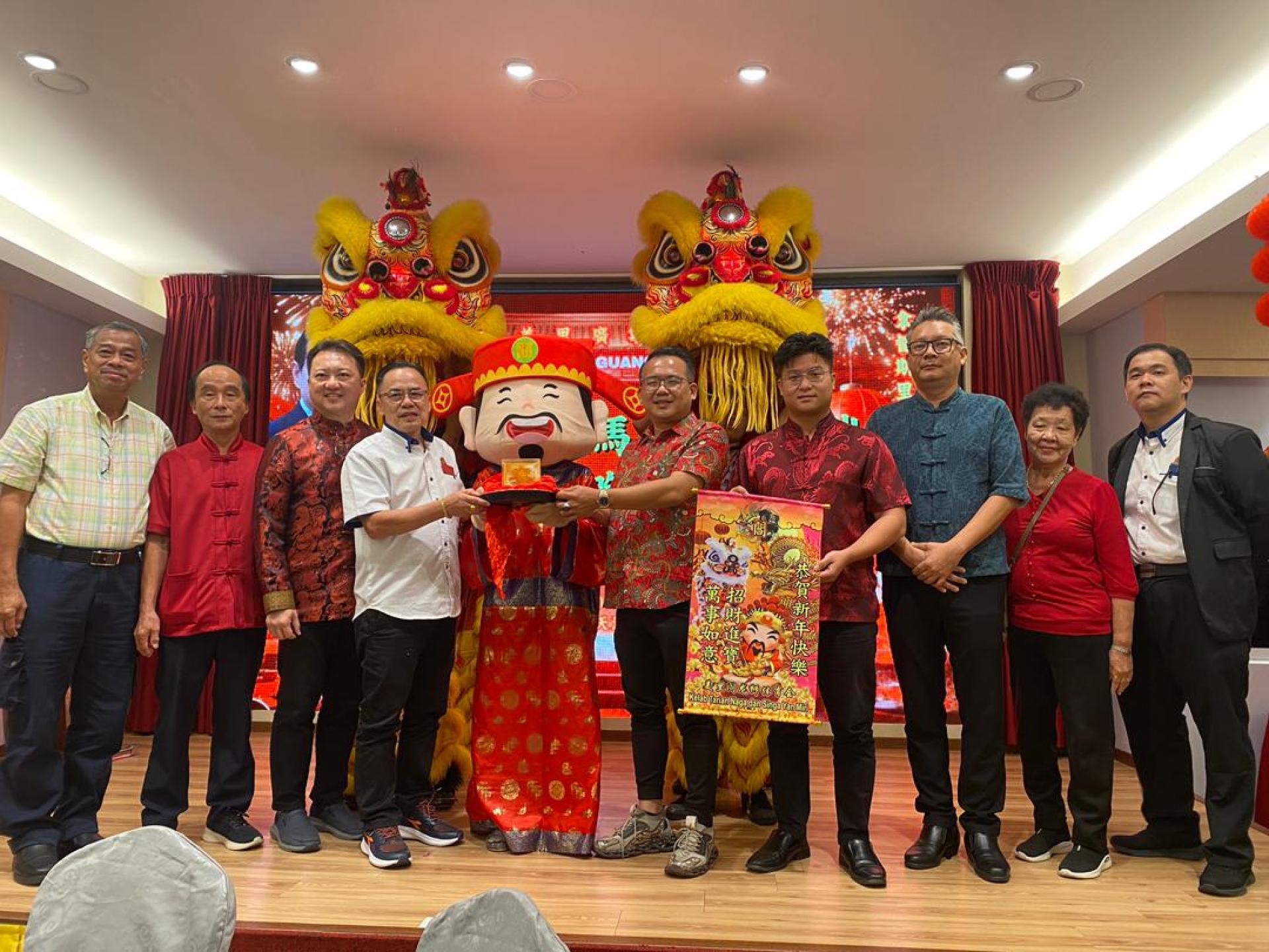 会长邵米华（左4）及主宾砂交通部长拿督斯里李景胜的代表熊千雨市议员（右5）在众嘉宾陪同下，从财神爷手中接过新春贺礼。