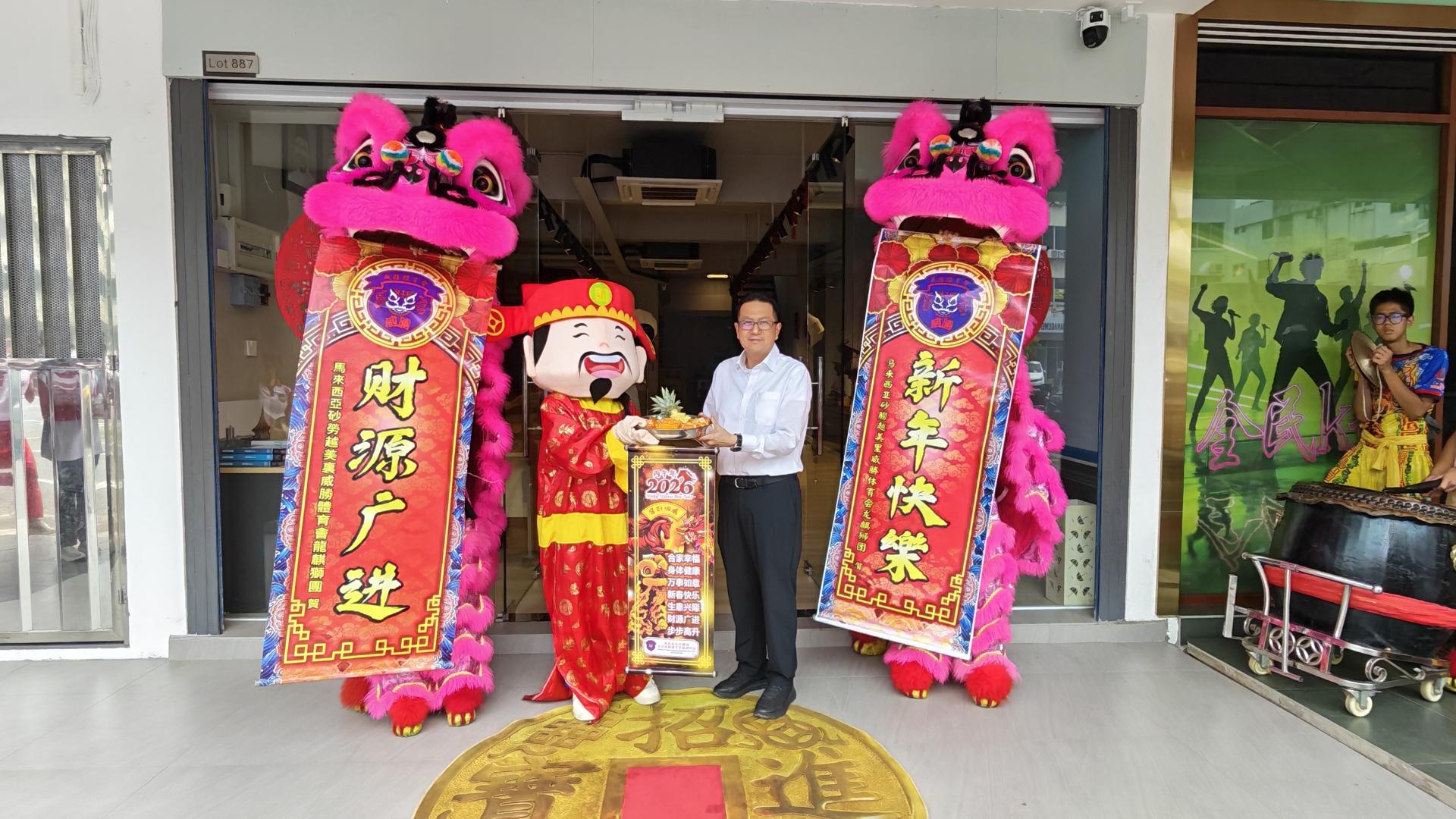 《联合日报》董事经理沈永亮从财神手中接过贺礼。