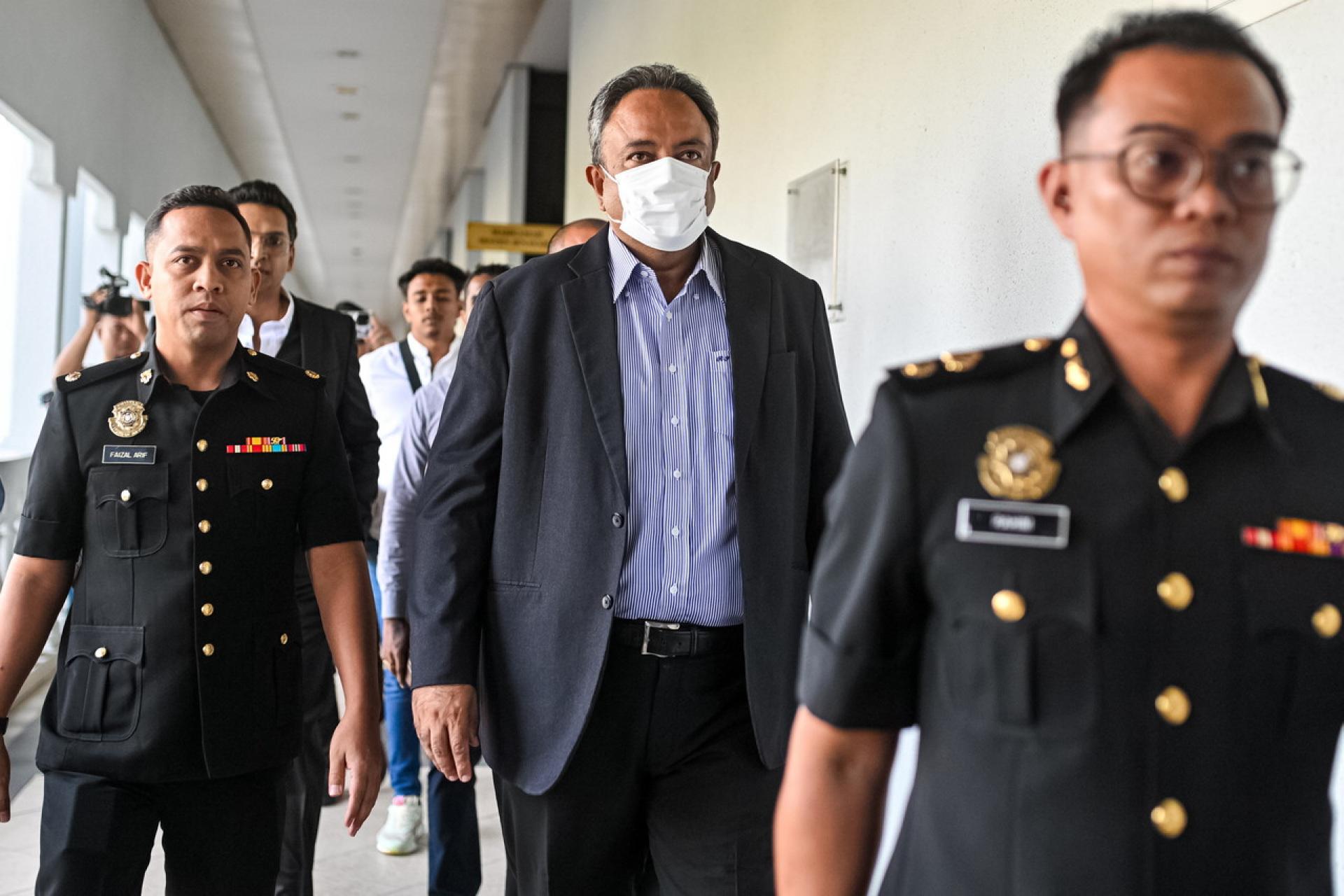 兰吉星（中）周一被控上隆地庭，面对行贿800万令吉控状表示不认罪。