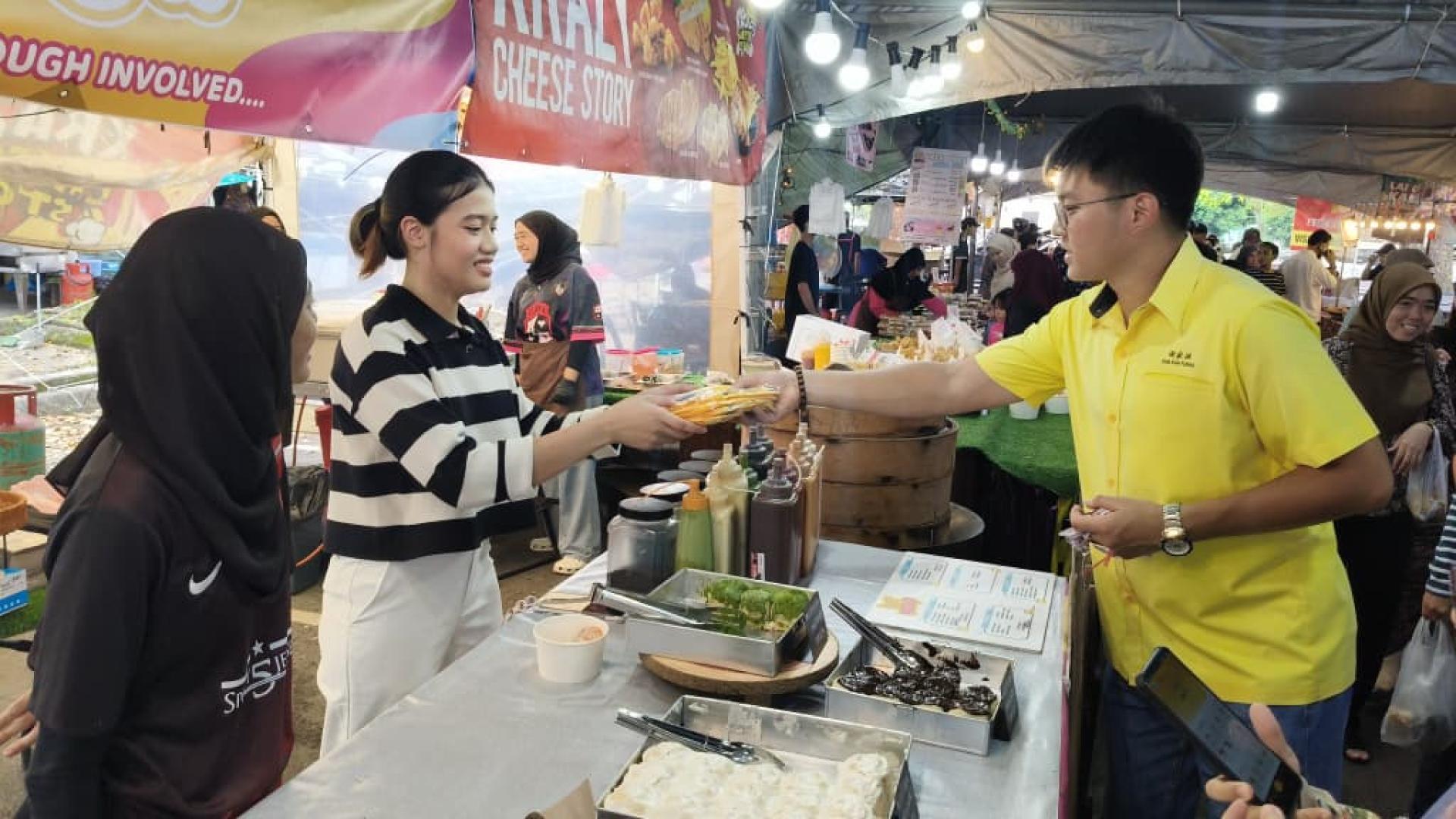 陈超耀机要秘书谢家洪派送围裙予小贩。