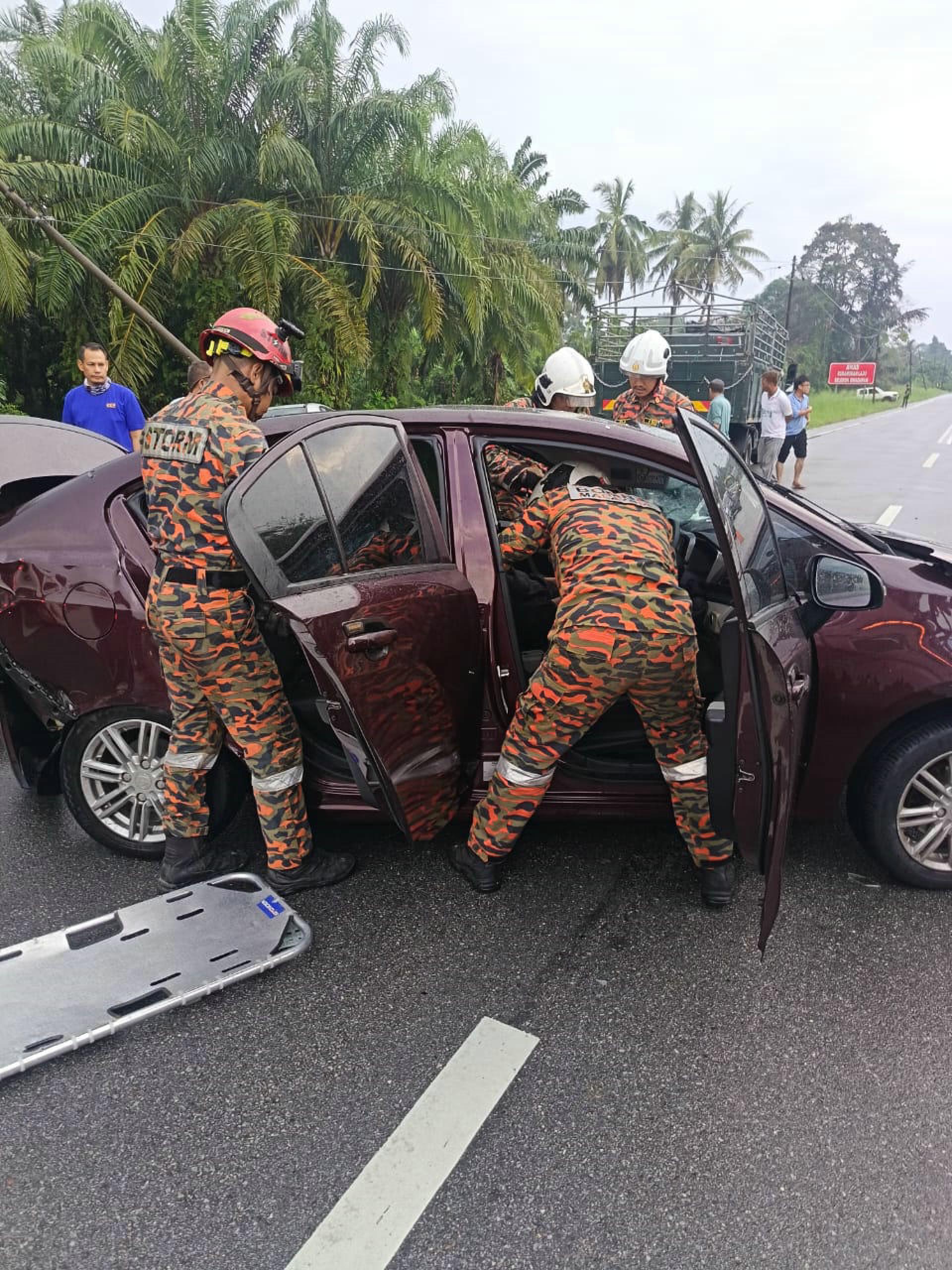 消拯员奋力抢救宝腾奔舒娜轿车受困的妇女。