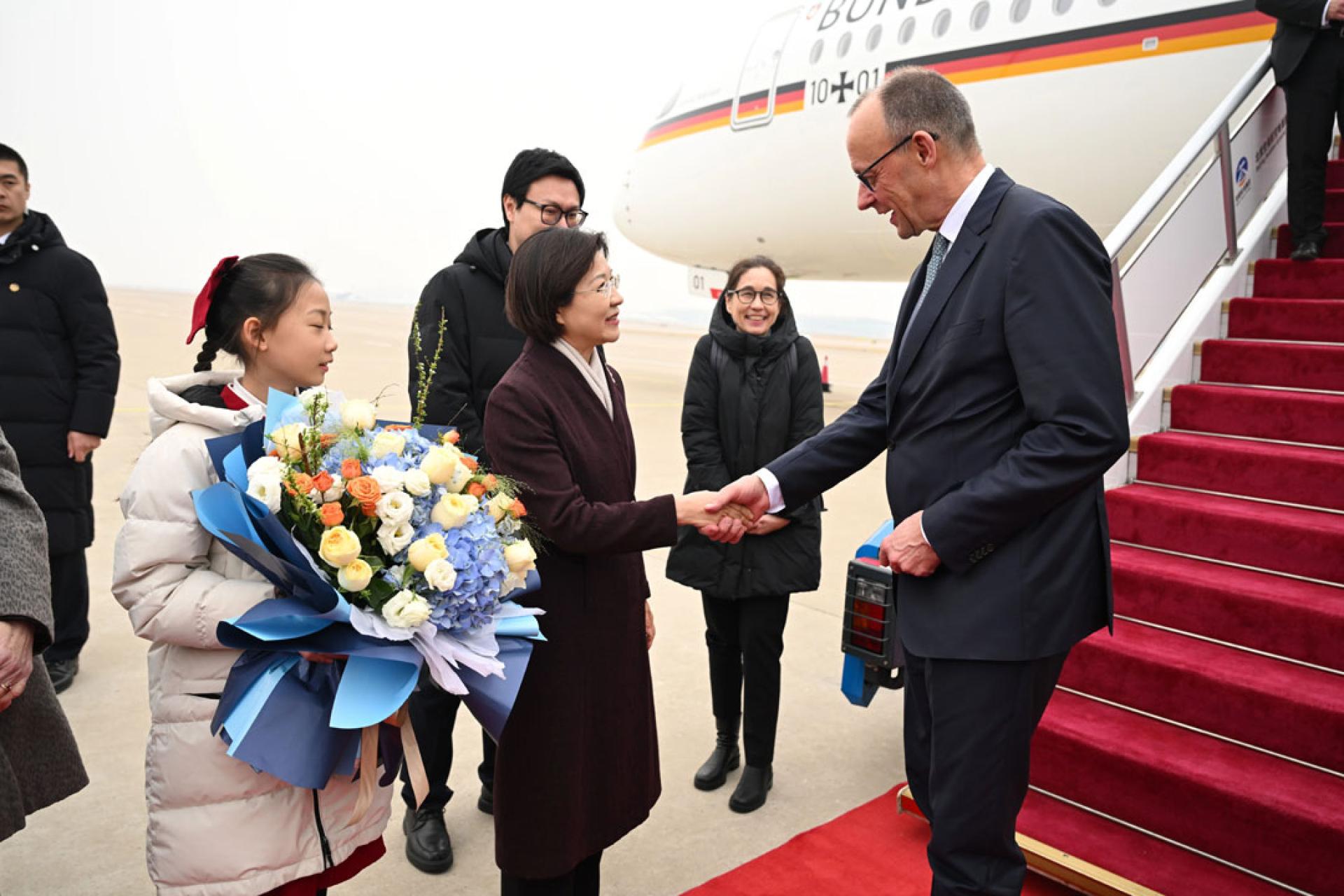 德国总理默茨（右）25日上午抵达北京，开始对中国进行为期两天的正式访问。（图：新华社）