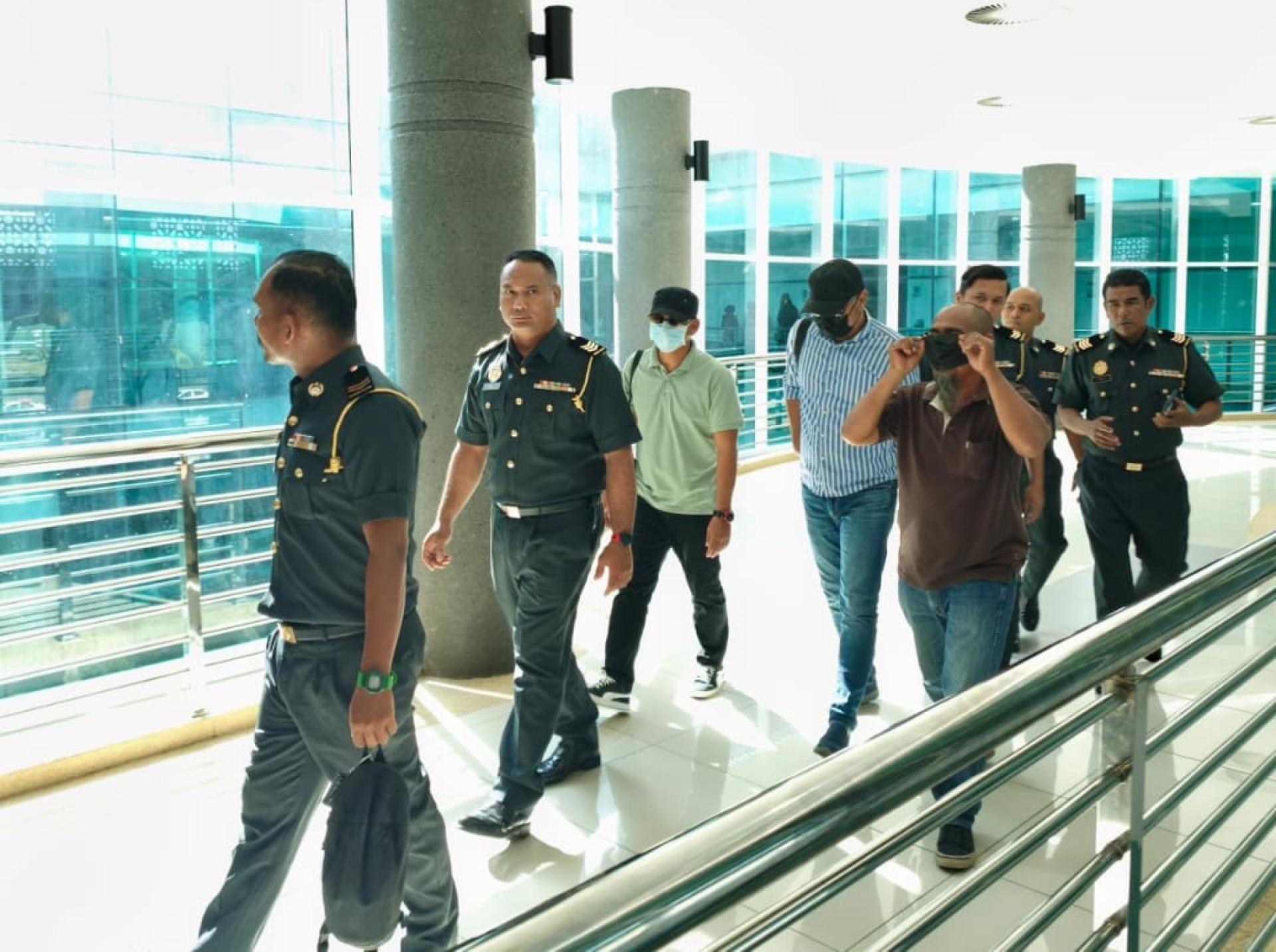 3名被告被SWCorp官员带出法庭缴付罚款时，戴口罩遮脸避开镜头。