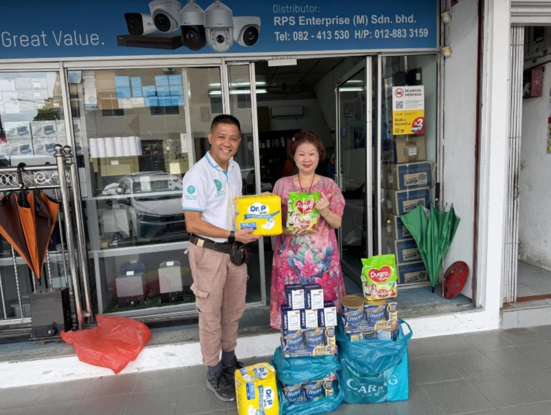 Lau Hong Eng将物资交予Kelvin Wan。