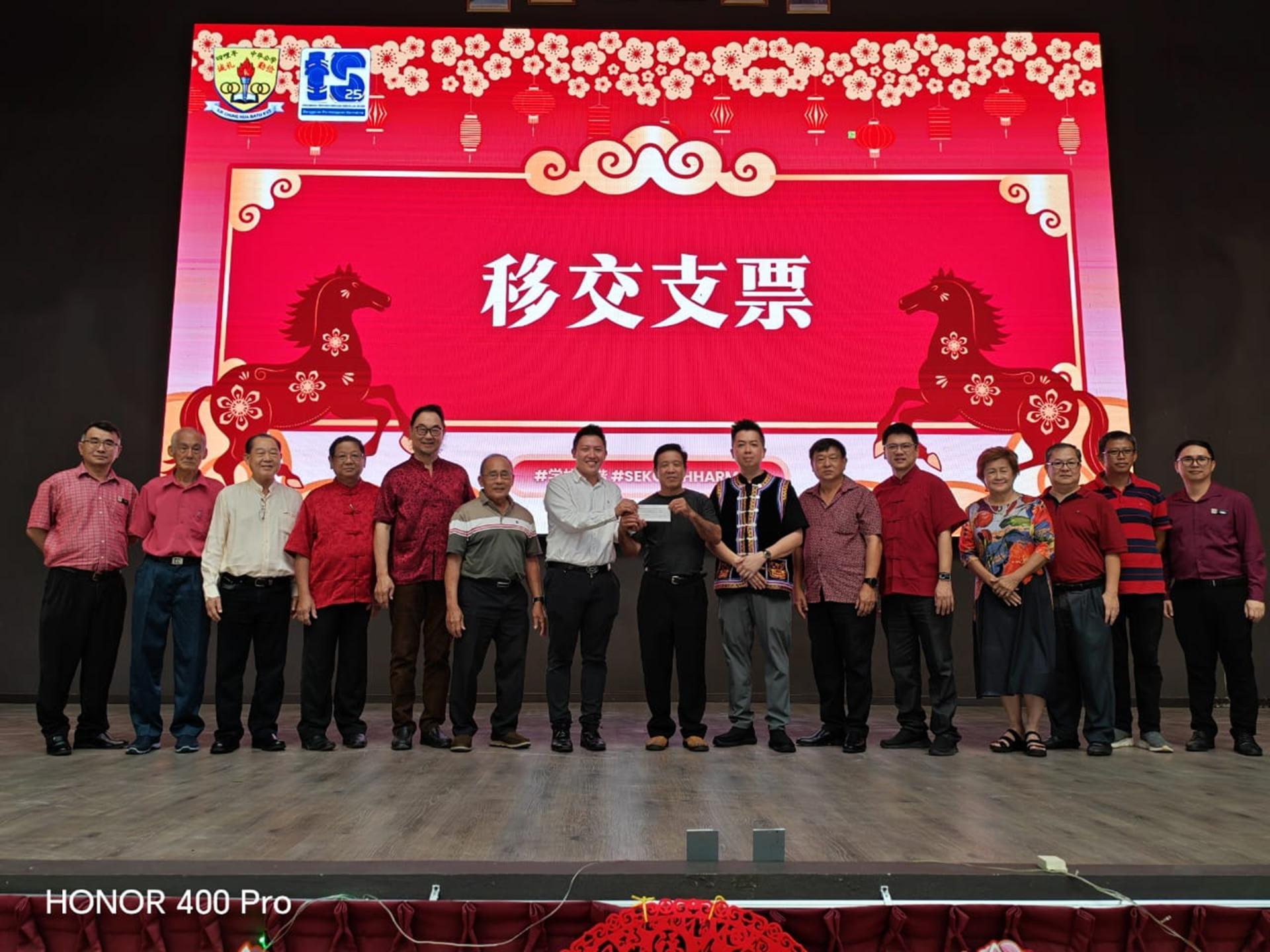 实旦宾区国会议员张健仁特别助理沈杰龙（左7）在众校董的陪同下，移交张健仁国会选区服务中心拨款支票予四哩半中公校董会。