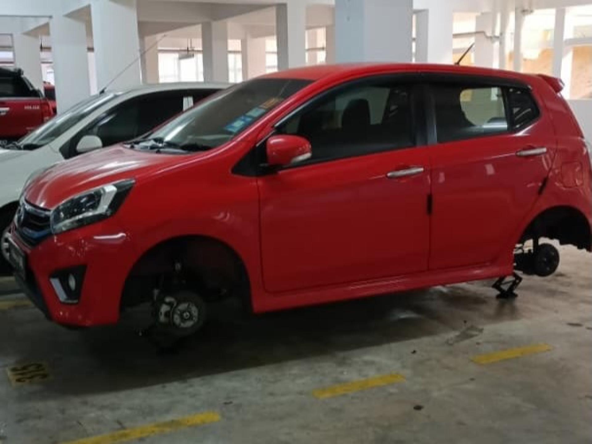 红色Axia的四个轮子被盗走，仅有千斤顶支撑。