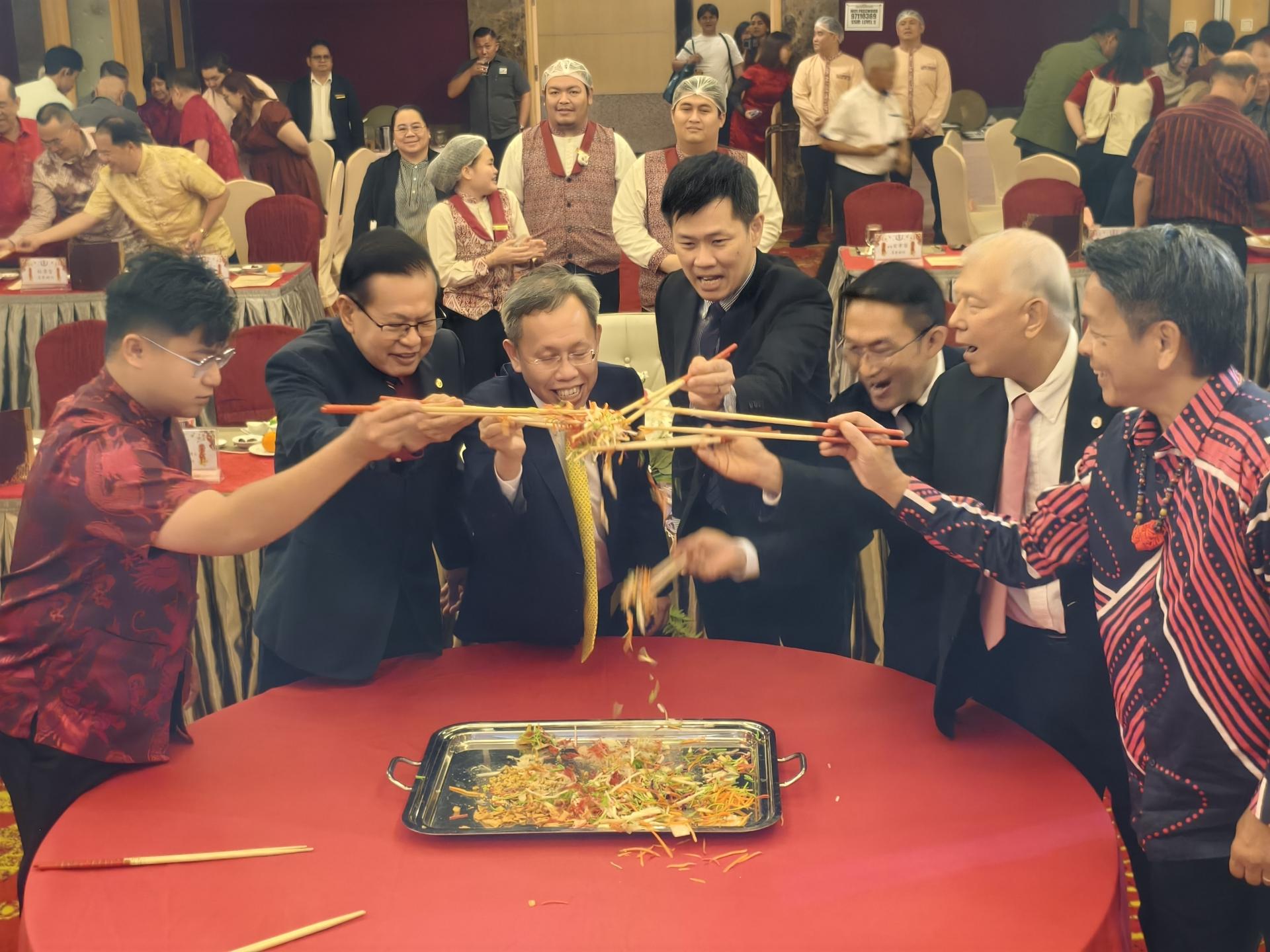 主桌嘉宾们一同参与捞生仪式，在欢愉气氛中共庆新春，祈愿来年兴旺吉祥。左起为马来西亚  旅游、艺术及文化部副部长兼美里国会议员赵俊文律师的代表邹梓建，砂拉越交通部长拿督斯里李景胜，砂拉  越副总理兼砂公共卫生、房屋与地方政府部长拿督阿玛沈桂贤医生，美里省华总会长兼砂华总副总会长许信隆  ，筹备会主席兼秘书长洪立川，砂旅游部副部长拿督陈超耀，以及砂拉越旅游局主席拿督丹尼斯奥。