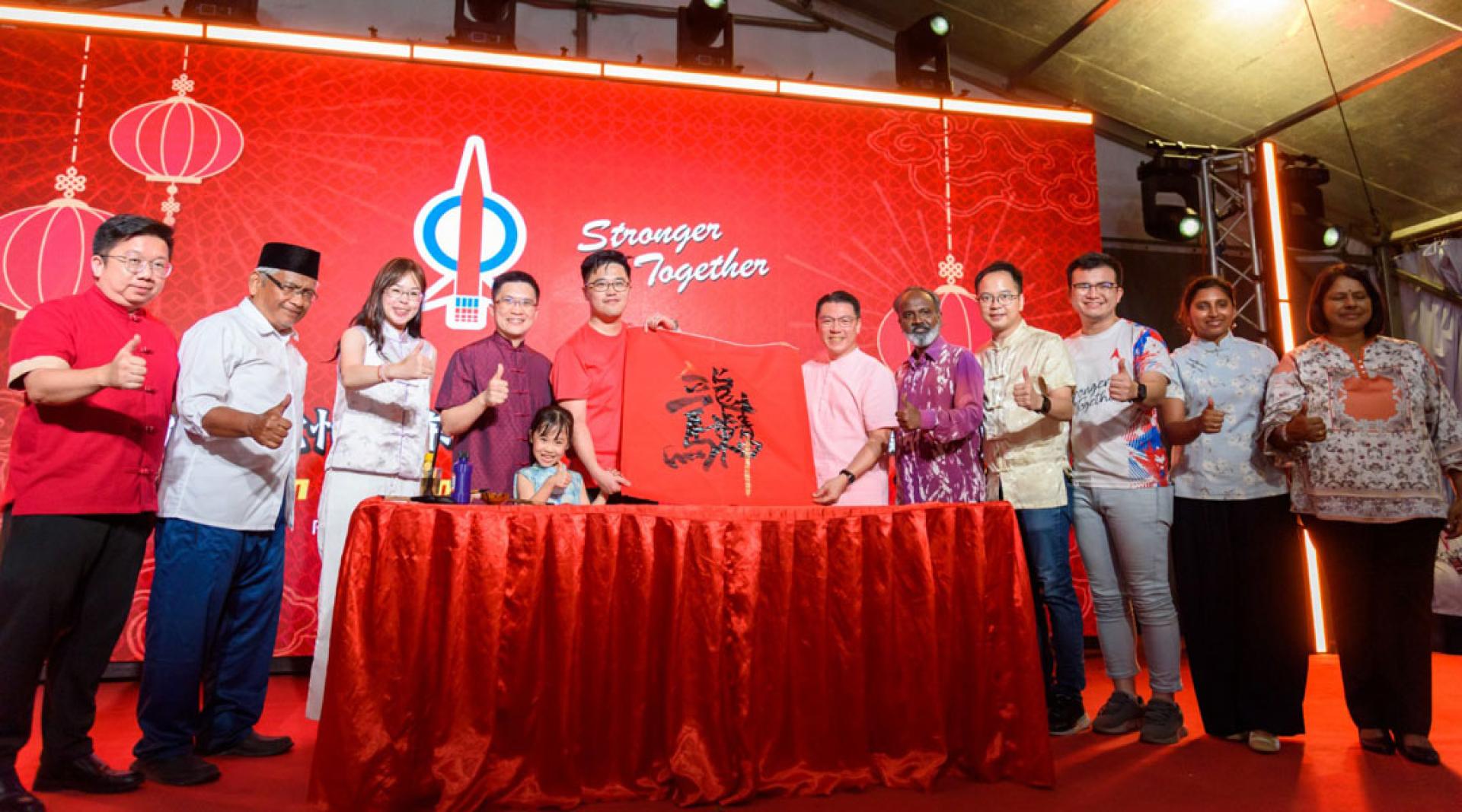 李存孝（左5）现场挥毫表达怡保东区是最强后盾最坚定骨干，推动成为霹州前进的核心力量。左起为周锦欢、阿都阿兹巴里、崔慈恩、黄家和；右起是莎莎、杜尔茜、张迪翔、吴锡华、西华古马及倪可敏。