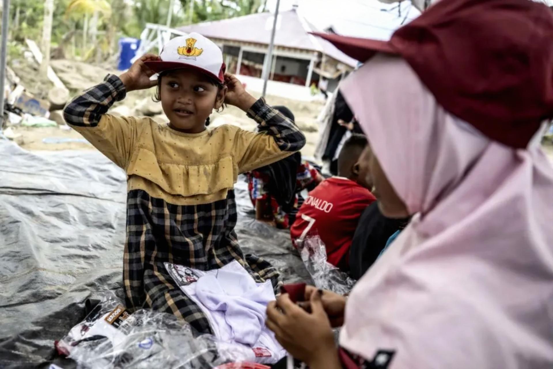 亚齐东部西朱多村兰托扬鲁贝克国立小学学生于21日在临时学校地点试戴派发的校帽。