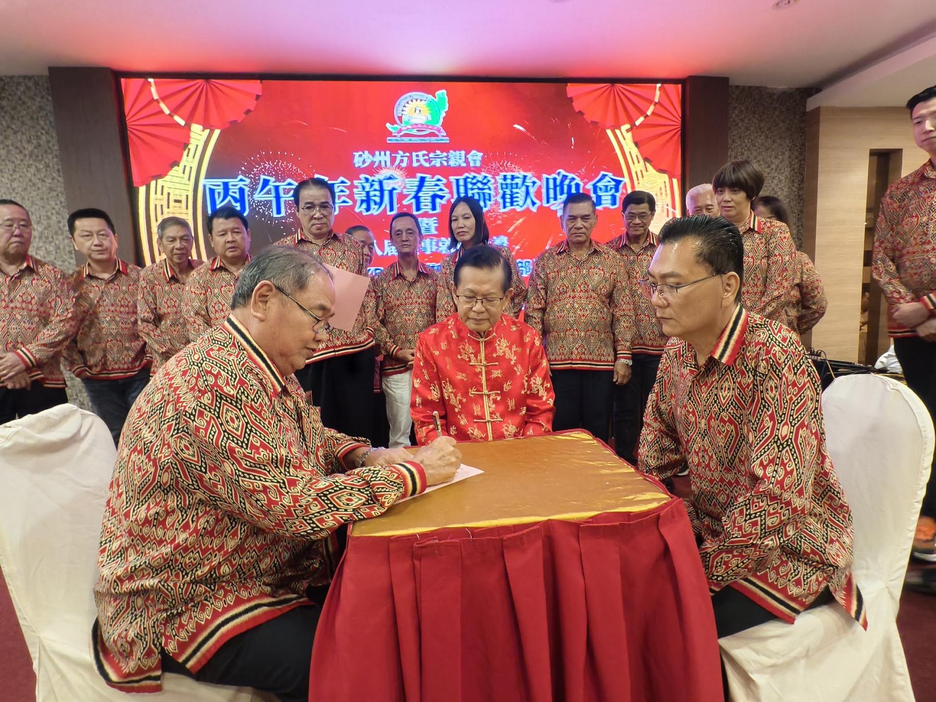 砂州方氏宗亲会主席方孝秀（左）在监誓人拿督斯里李景胜及永久名誉顾问拿督斯里方彦均博士（右）见证下，于宣誓书上签名。