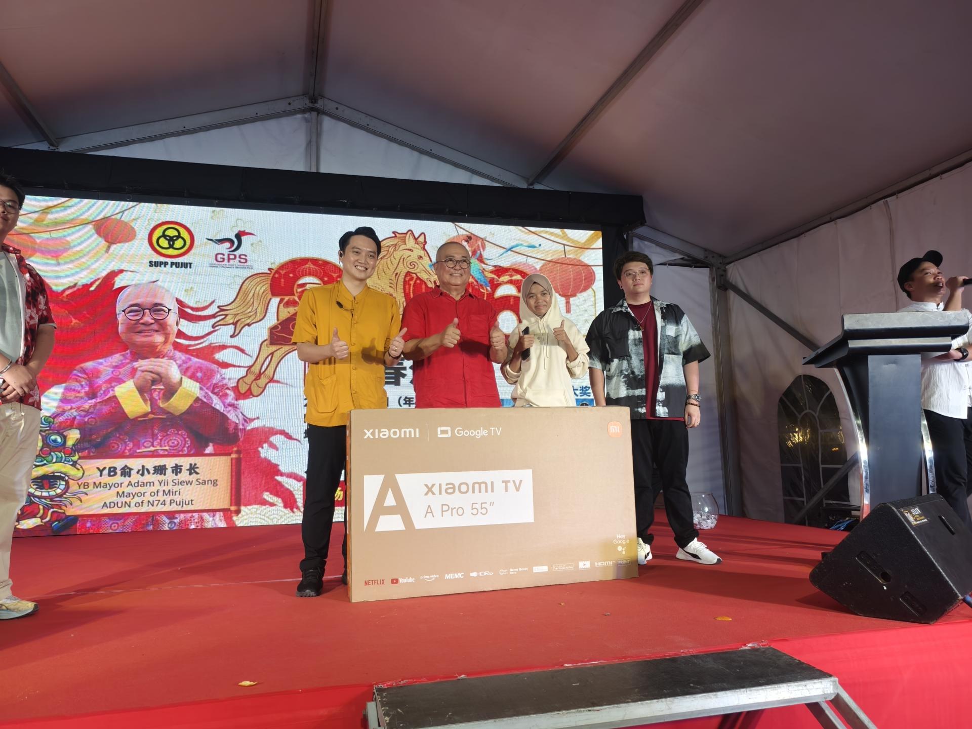 埔奕支部主席俞小珊（左2）颁发幸运抽奖巨奖予得主，现场掌声雷动，喜气洋洋。左为砂人联党埔奕支部青年团团长许勋扬。