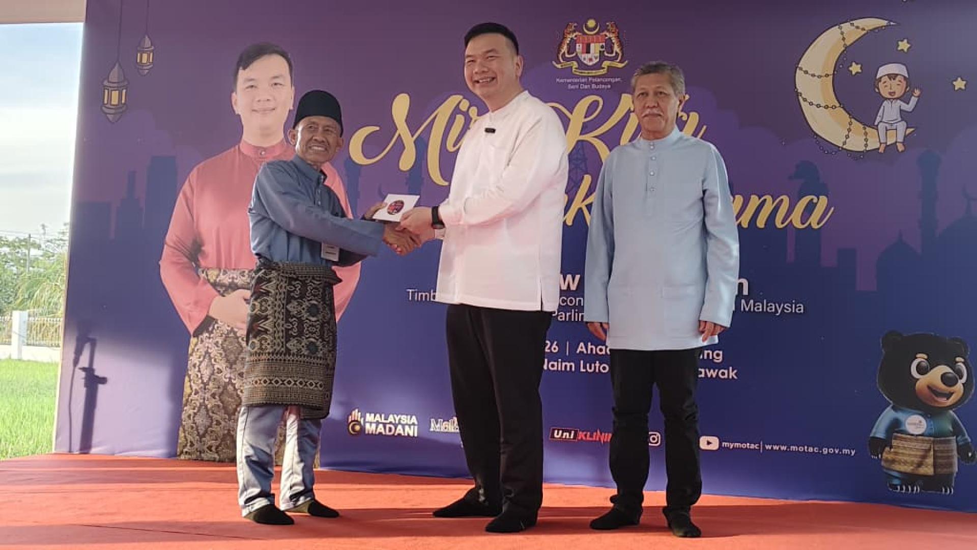 旅游、艺术及文化部副部长兼美里区国会议员赵俊文（中）移交斋戒月捐助给各受惠组织代表，罗东安纳英清真寺管理委员会主席奥玛（左）。