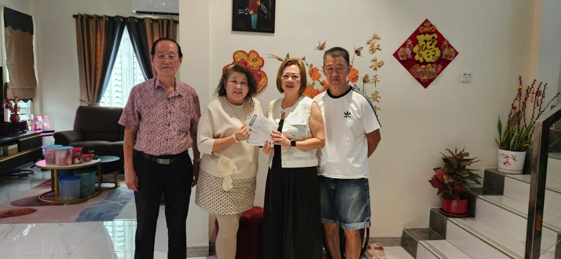 林学园邱秀芳伉俪（左）将善款移交予汶莱华人慈善会理事沈秋香