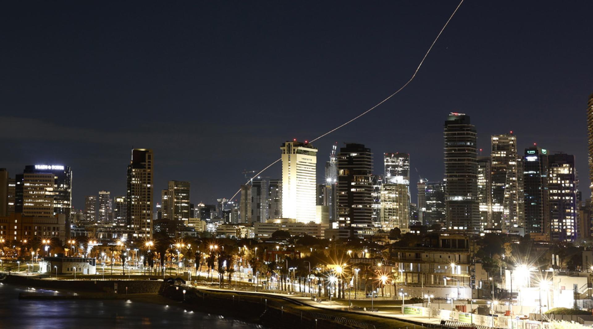 以色列遭遇伊朗还击，特拉维夫1日晚再次遭到来自伊朗导弹的袭击。图为以军防空系统发射拦截弹后留下光轨。（图：新华社）