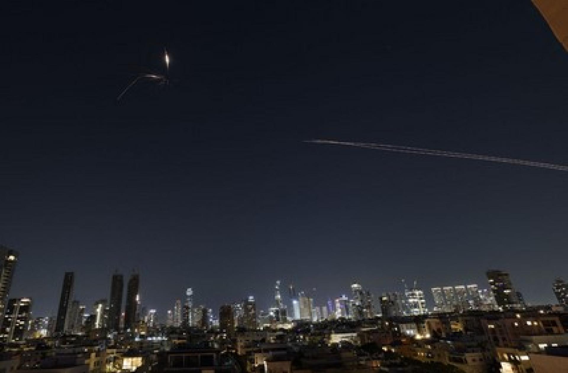 伊朗3日对以色列沿海城市特拉维夫发动新一轮导弹袭击，天空中清晰可见火箭飞过的烟尘轨迹。