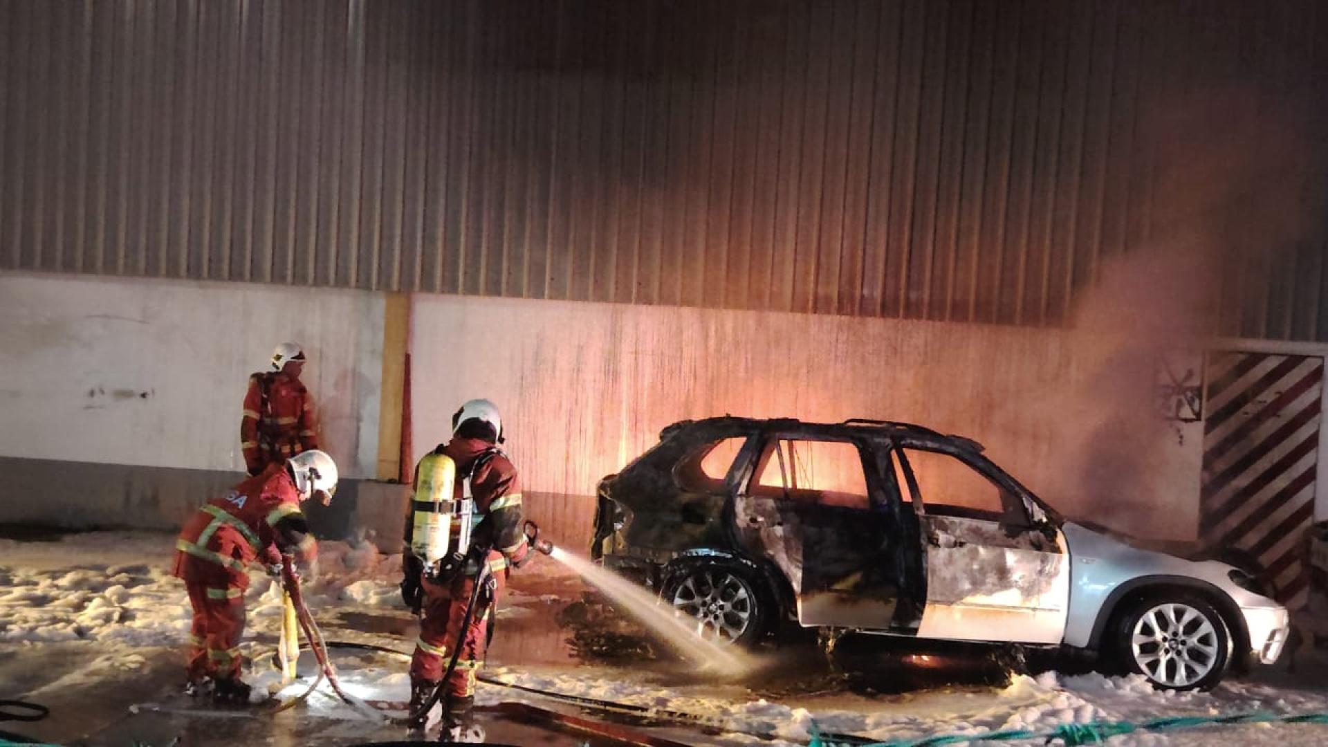 卑尔骚一间物流公司范围内一辆宝马轿车起火燃烧，消拯人员使用泡沫与水源进行灌救。