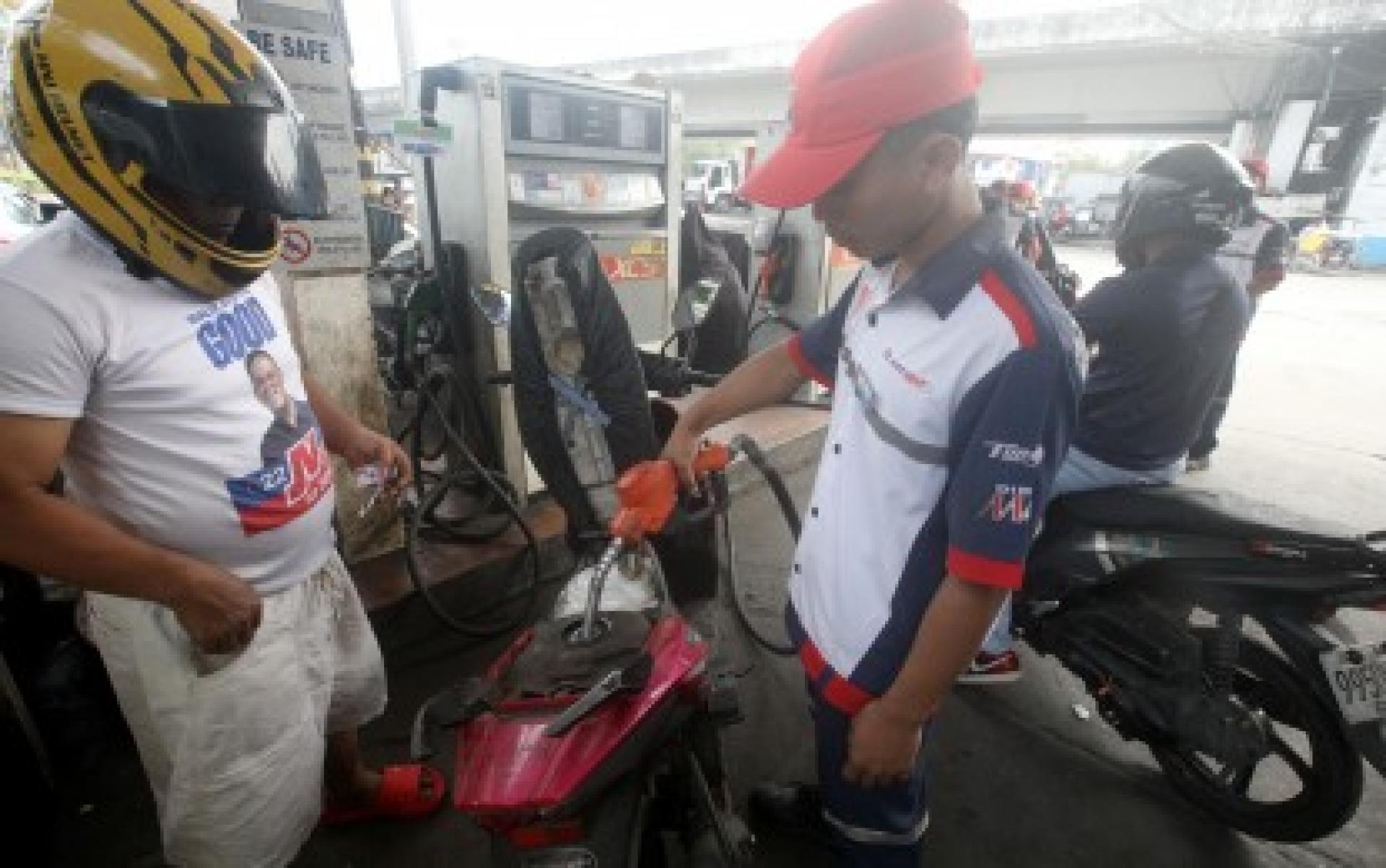 3月2日，在马尼拉汤都区德尔潘的一家加油站，一名加油员正在给一辆摩托车加油。