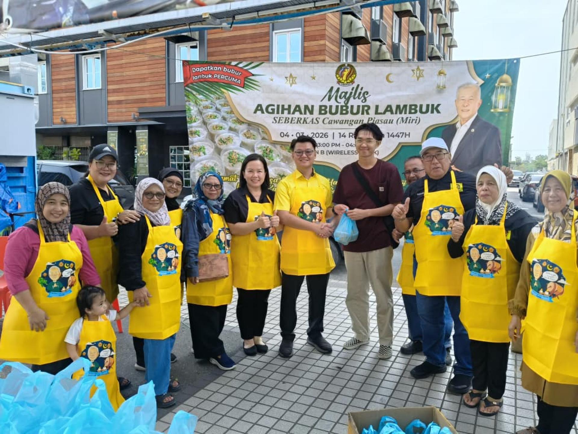 砂旅游副部长陈超耀代表、砂人联党卑尔骚支部青年团团长兼市议员刘奕杰（右5）派送杂锦粥予民众，右3为砂青统卑尔骚支部主席尤索莫哈末。