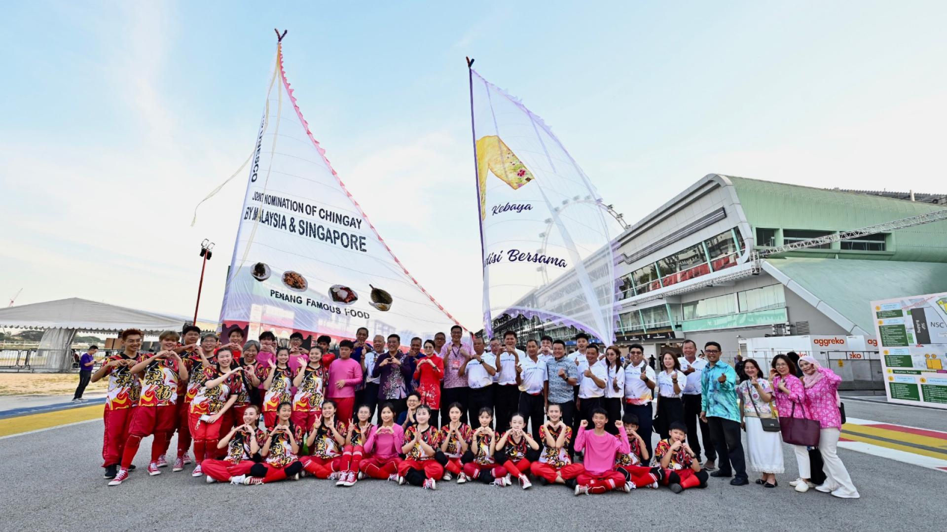 槟城大旗鼓队、柔佛高跷队，槟州政府一行以及大马旅游、艺术及文化部代表，于新加坡妆艺大游行开始前合影。（第二左9起）黄汉伟及陈汇萍等人。（图由黄汉伟提供）