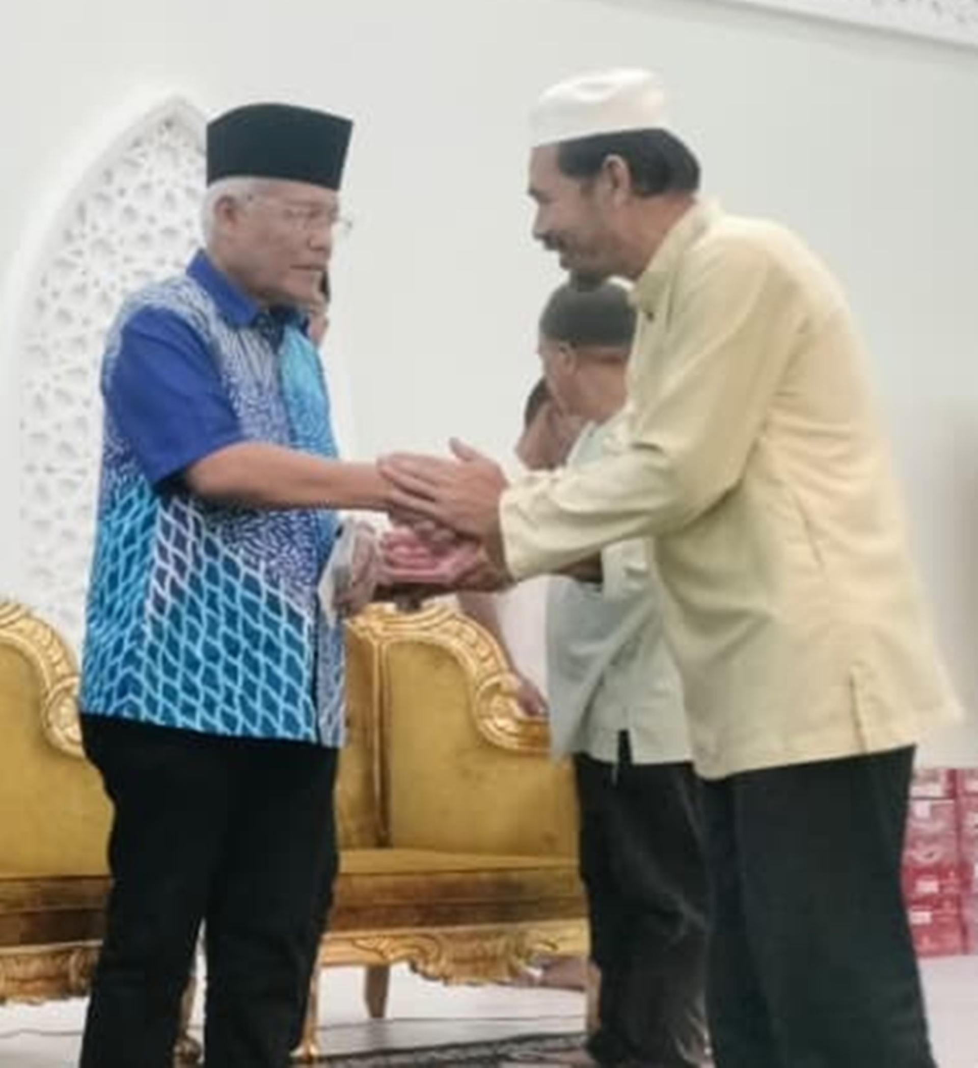 韩沙再努丁（左）移交捐款予祈祷室与清真寺负责人。