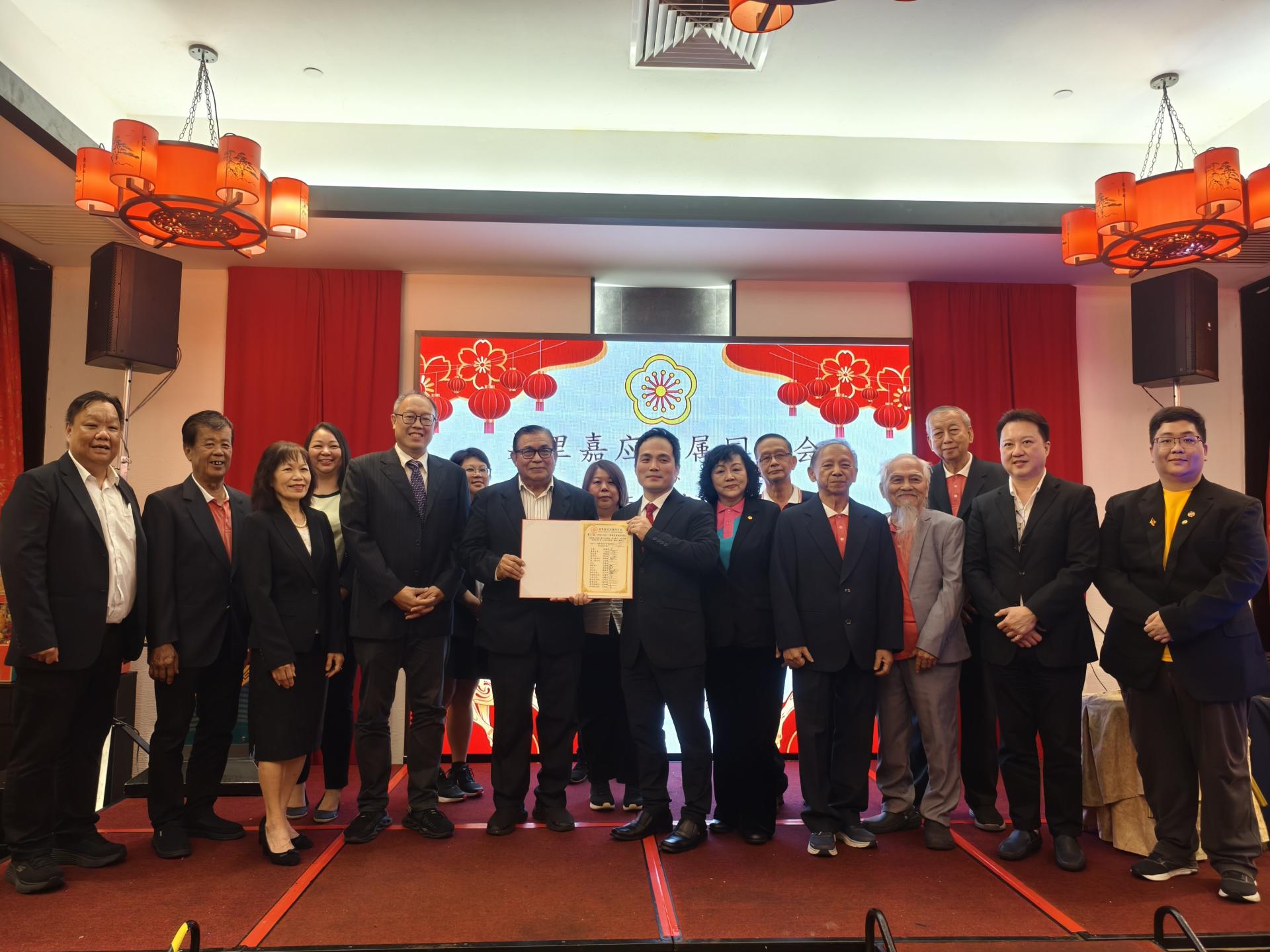 监誓主宾砂拉越交通部长拿督斯里李景胜的代表本固鲁蔡刚明（左者）移交宣誓书给美里嘉应五属同乡会主席张嵻洺。