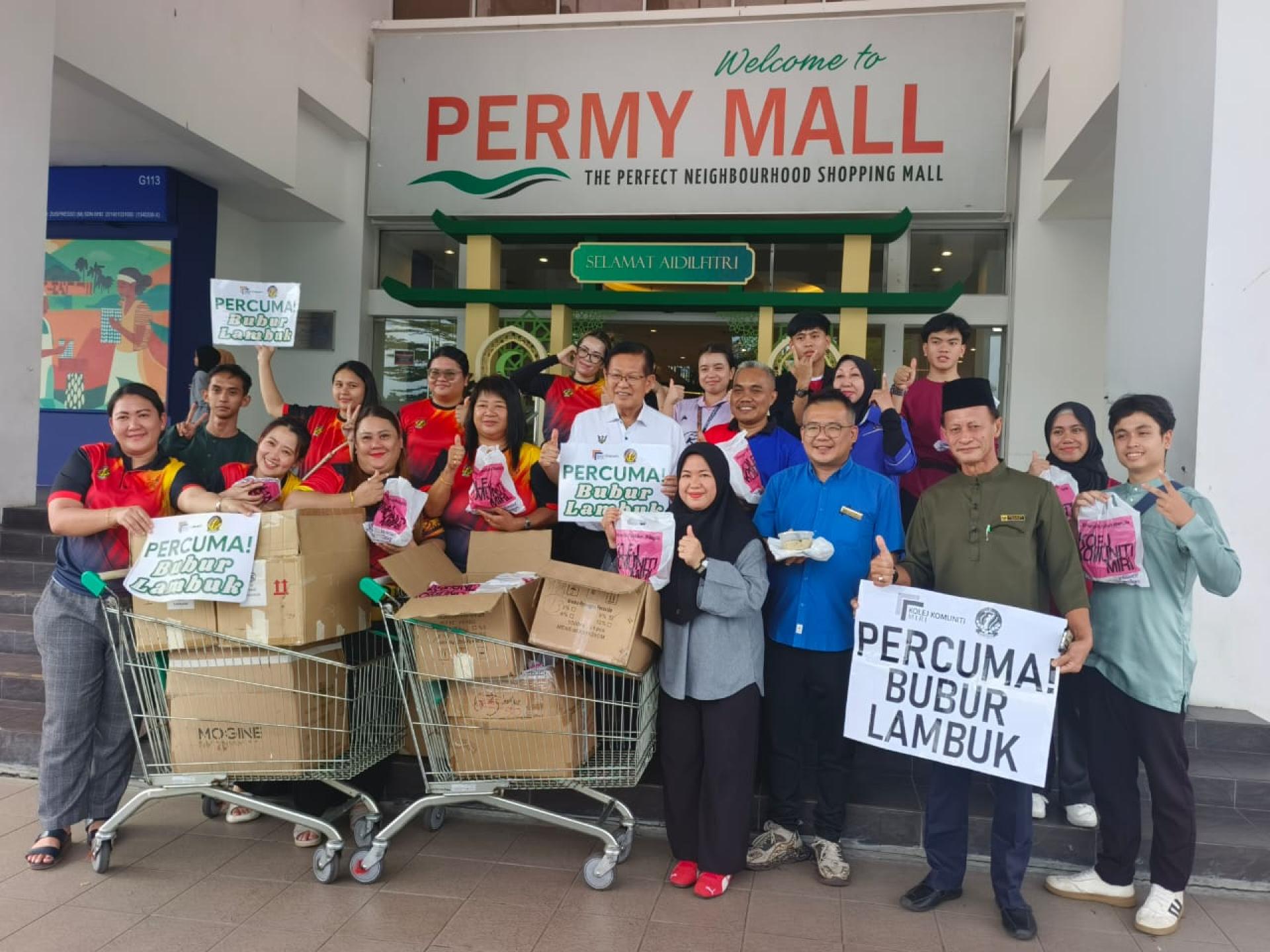 砂拉越交通部长拿督斯里李景胜（中）出席在柏迈广场入口处举行的斋戒月派发杂锦粥活动，并与主办单位代表合影。