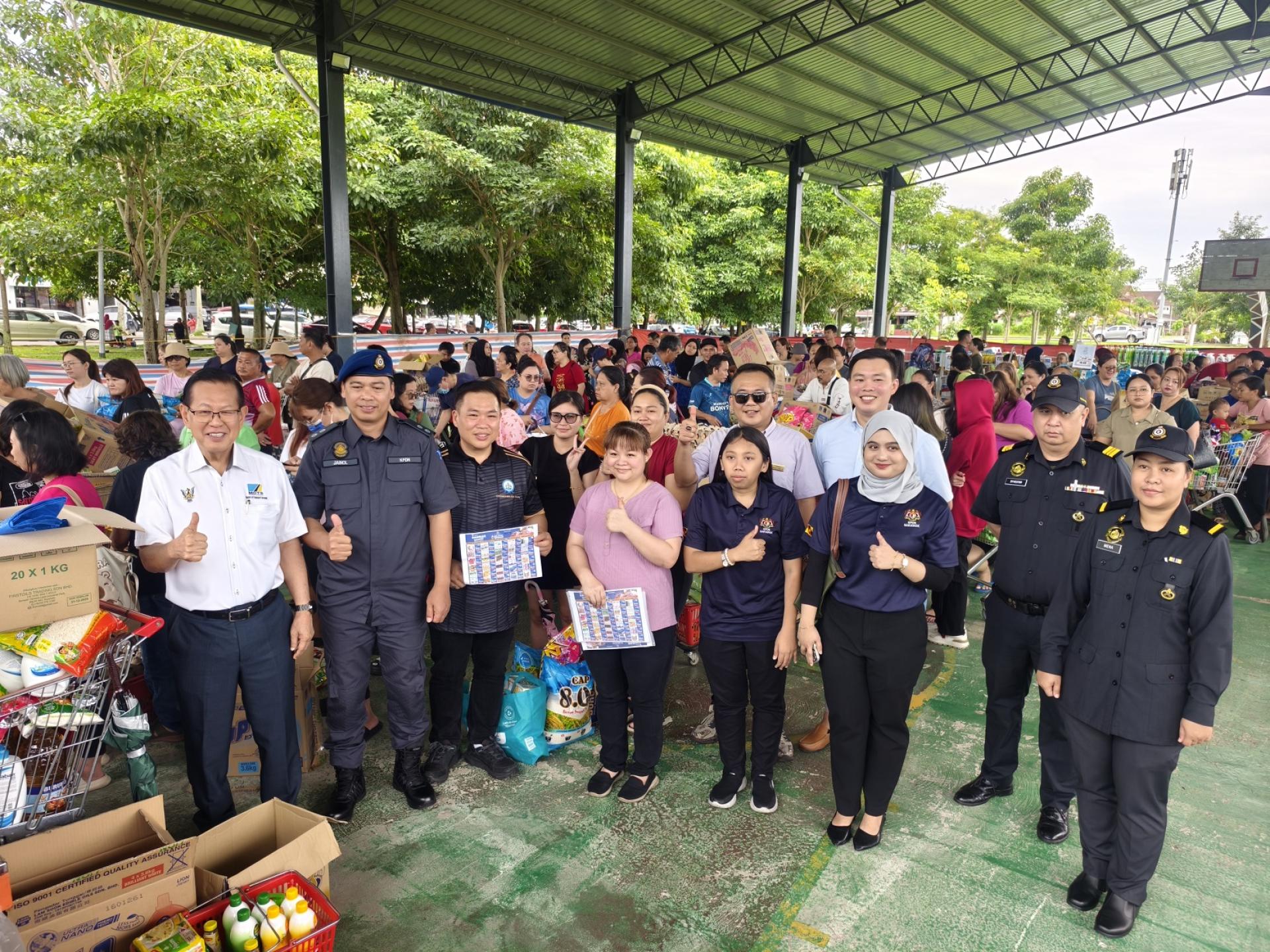 砂拉越交通部长兼史纳汀区州议员拿督斯里李景胜（左）与国内贸易及生活成本部官员及工作人员合影，感谢各方合作推动昌明怜悯销售活动。