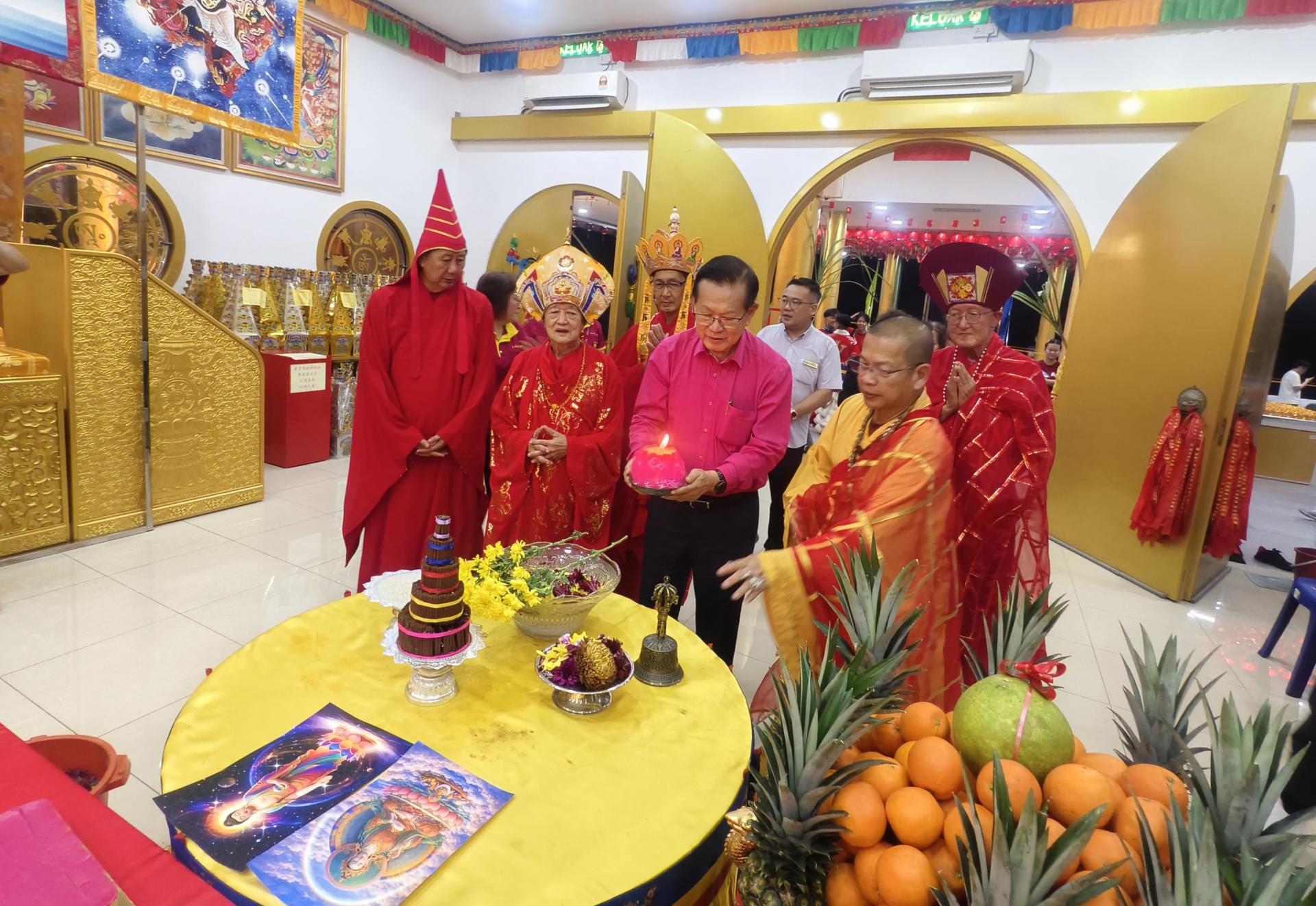 砂交通部长拿督斯里李景胜（右2）主持点灯仪式，为新春祈福法会掀开序幕。右为美里佛教静  修会主席蔡顺登。