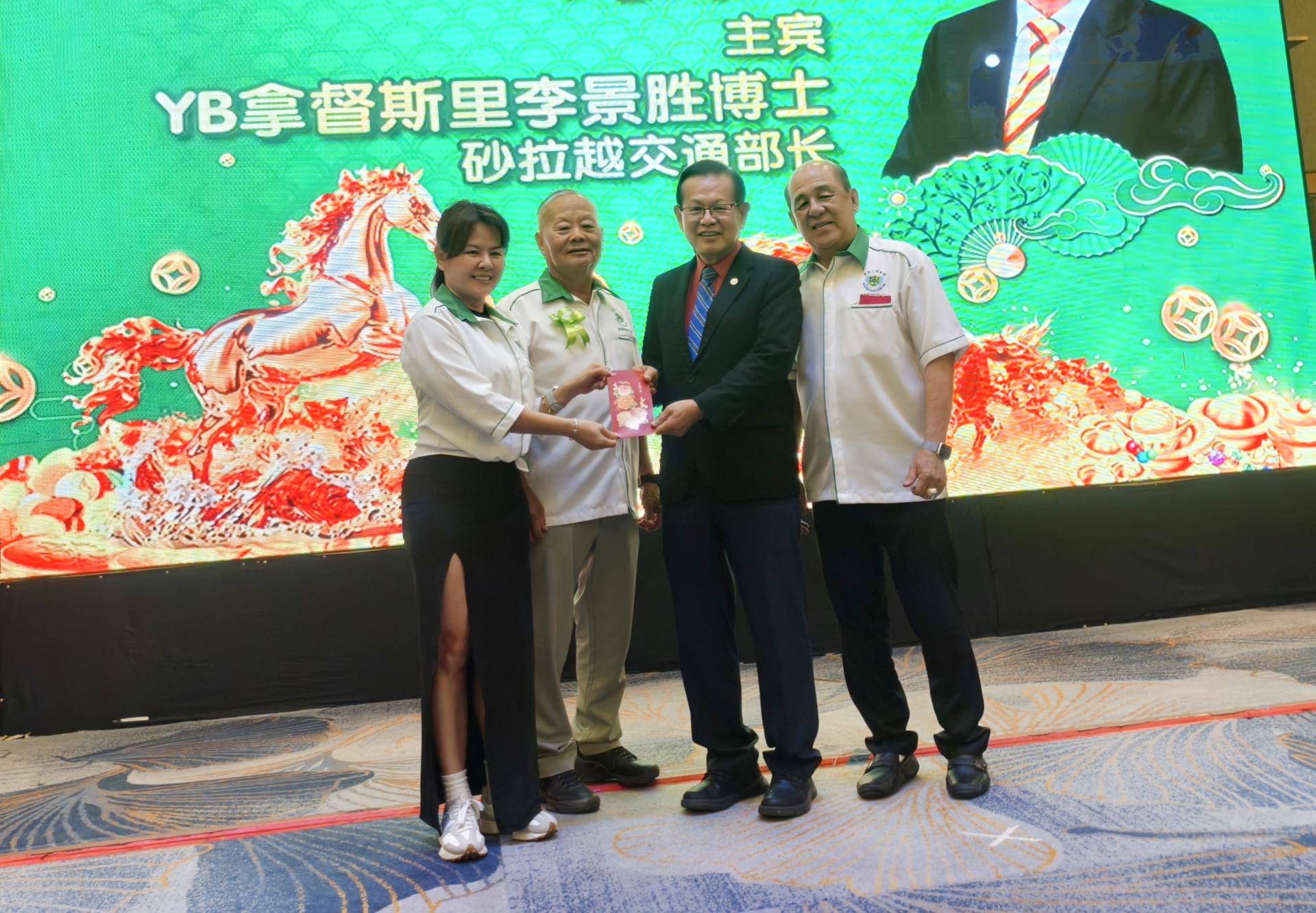 筹备会主席菲歐娜李（左）赠送主宾砂拉越交通部长拿督斯里李景胜（右2）祝福红包。左2为会长拿督斯里刘久健，右为主席郑春伟。