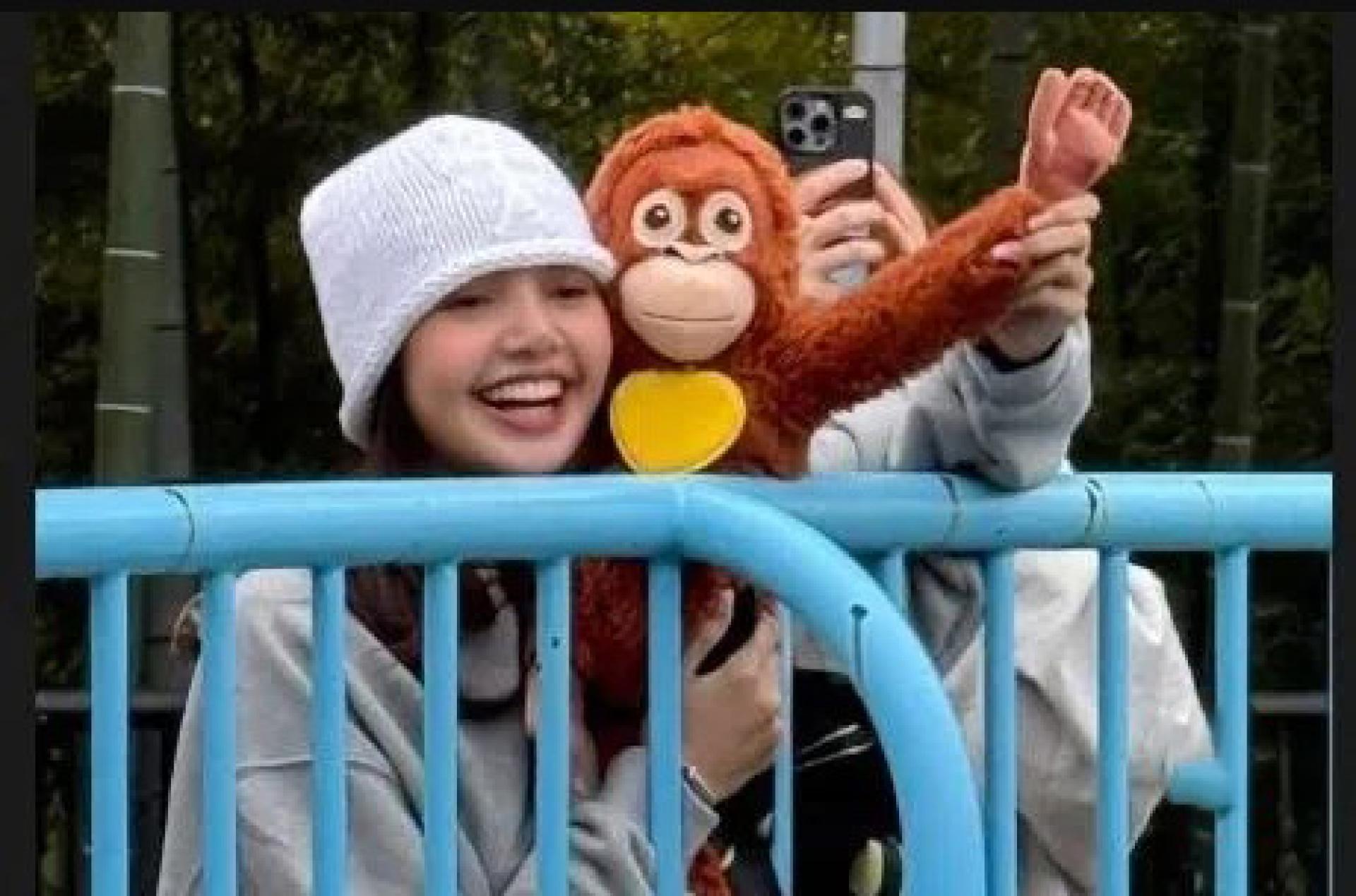 Lisa 看到小猴Punch时开心地露出笑容。