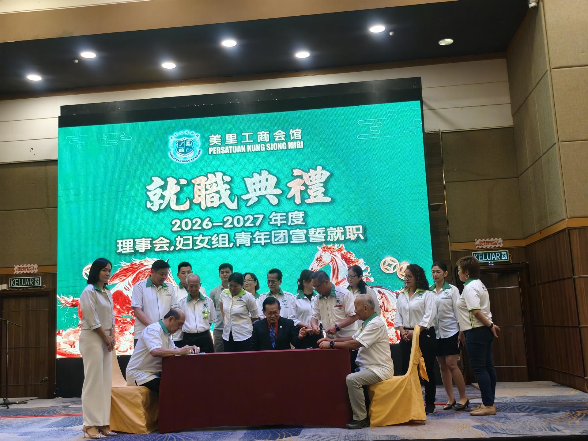 主席郑春伟（左）在宣誓书上签名。