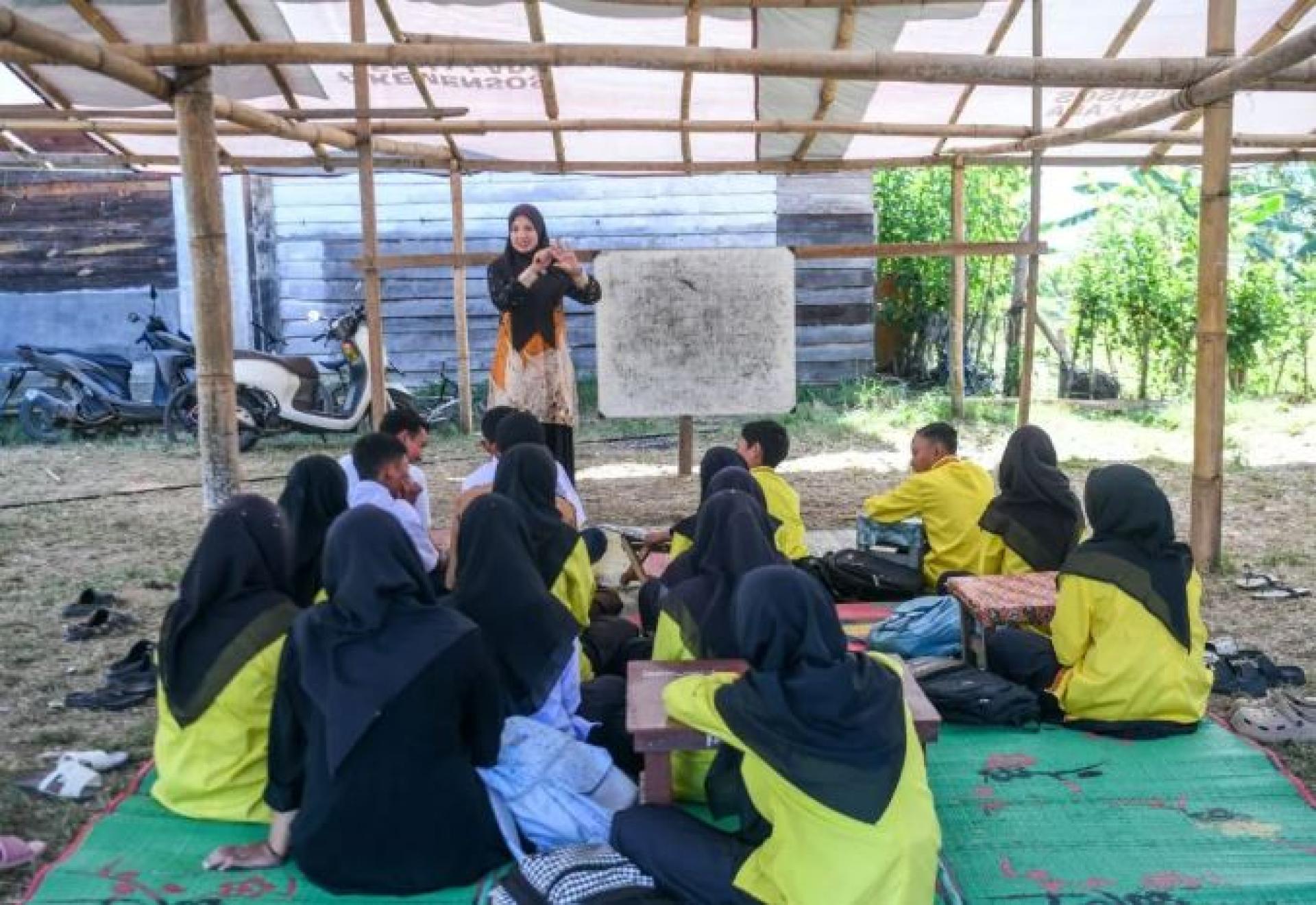 2026年1月29日，亚齐加约卢斯洪灾区，一名教师在临时搭建的教室里授课。（ 档案照）