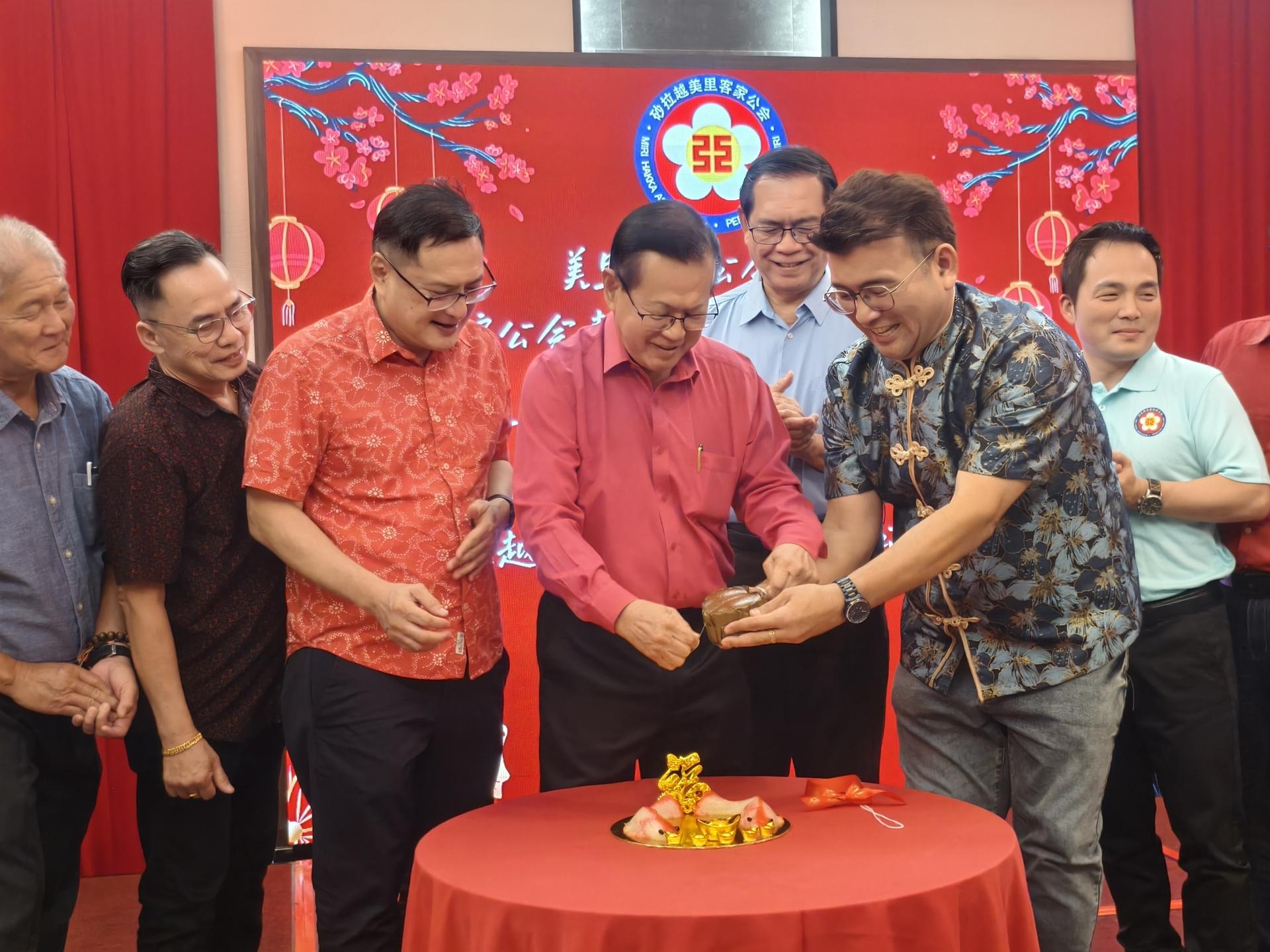 砂交通部长拿督斯里李景胜（左4）以拉线方式切开年糕，为美里客家公会青年团新春暨客家天穿日联欢晚宴主持开幕仪式。