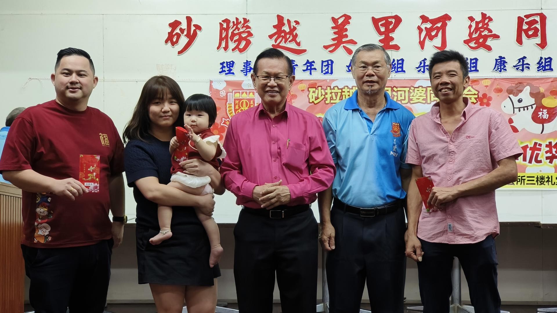 拿督斯里李景胜（右3）在会长蔡传创（右2）陪同下，派发会员添喜奖予得奖家长。