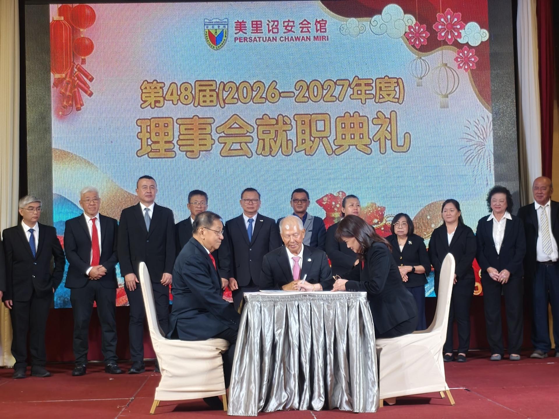 会长林美英在美里诏安会馆第48 屆理事宣誓书上签名。左起为砂章泉社团联合会总会长林贤德及砂拉越旅游副部长拿督陈超耀。