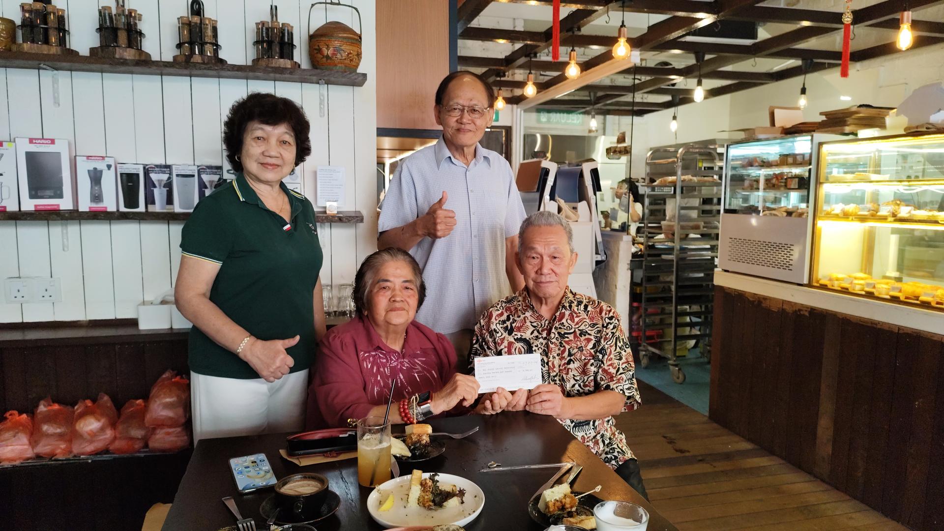 右起孙德安接受温素华赞助世华大会经费。