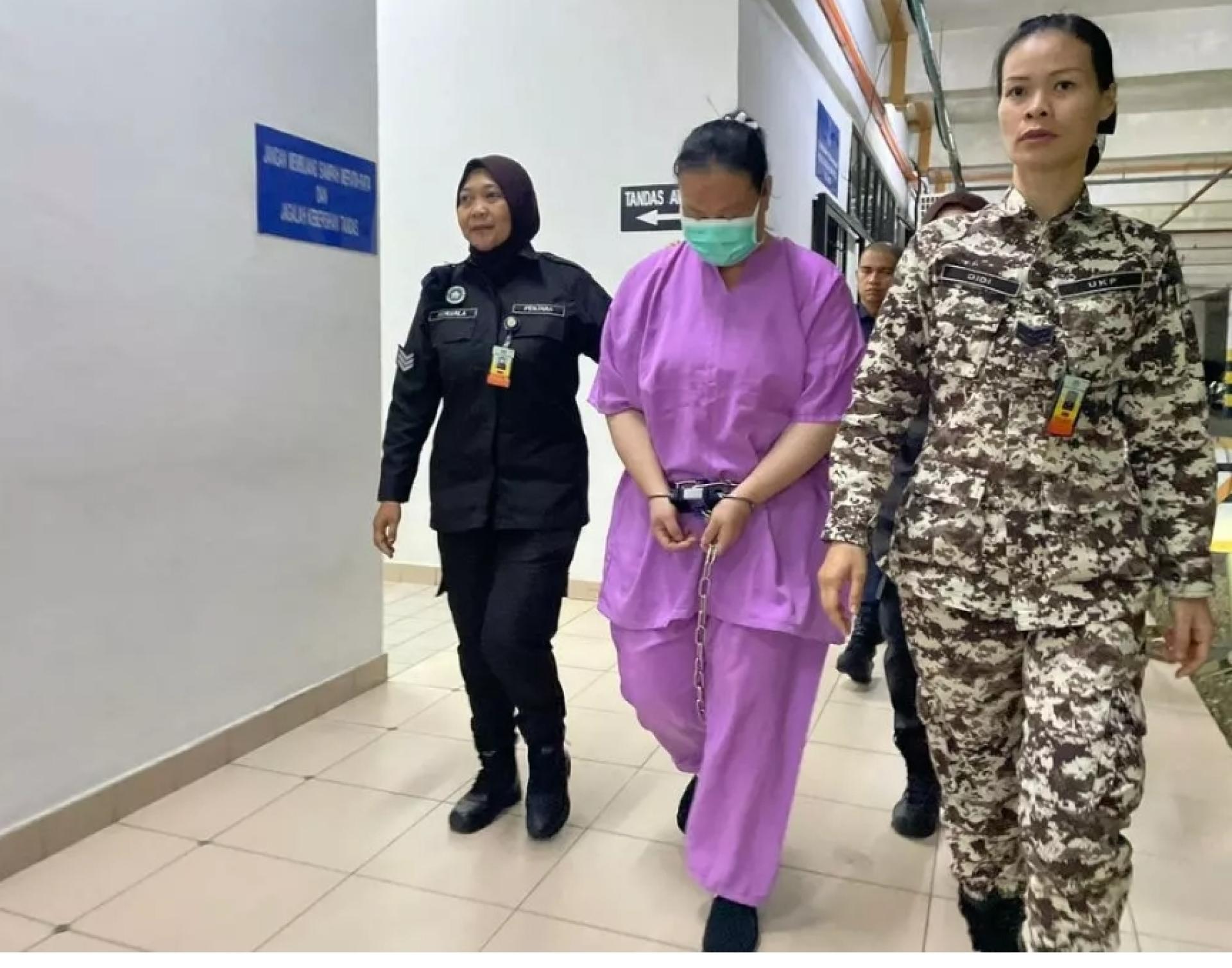 其中一名被告被押往法庭途中。