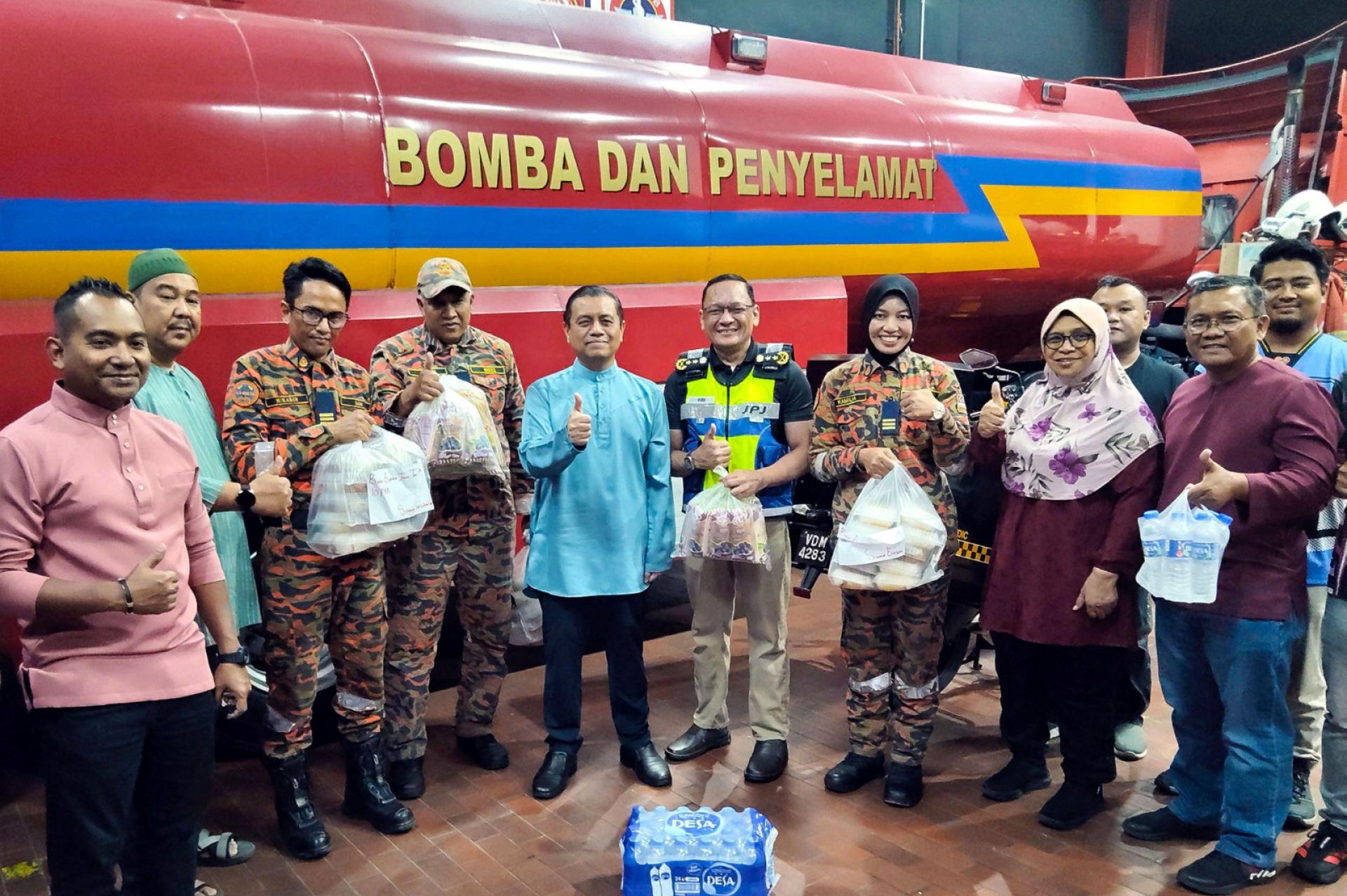 艾迪法德里（左5）移交餐食给消拯员。